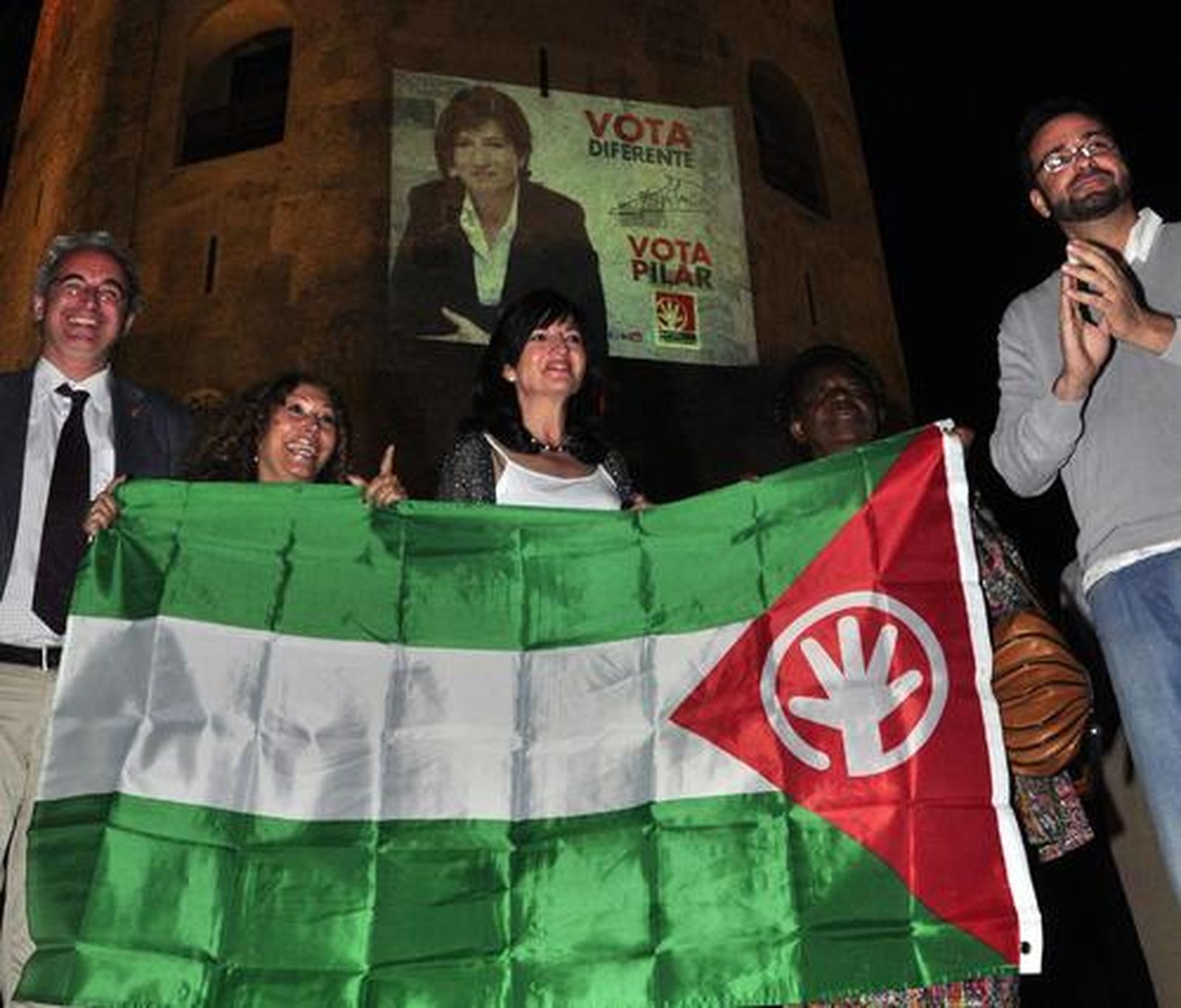 Pilar Gornzález y Pilar Távora, junto a los militantes frente a la proyección de su cartel electoral sobre la Torre del Oro.

Foto: Manuel Gómez