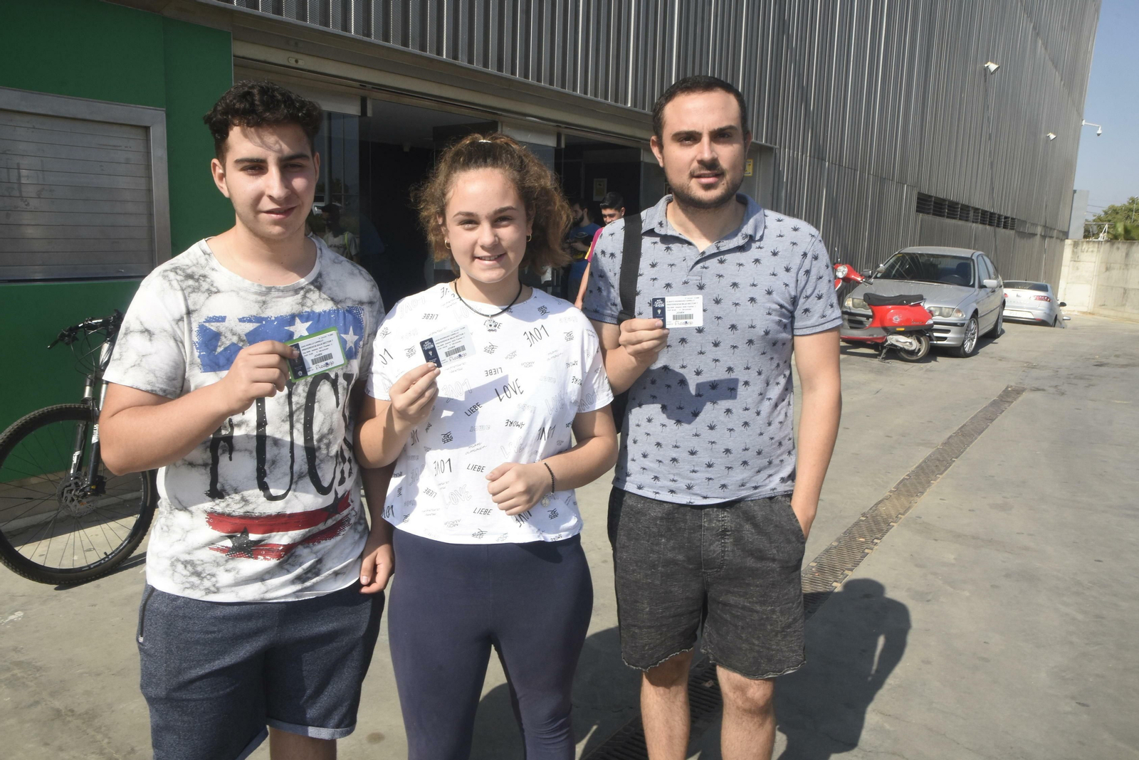 Tres jóvenes muestran su carné de abonado a las puertas de El Arcángel.