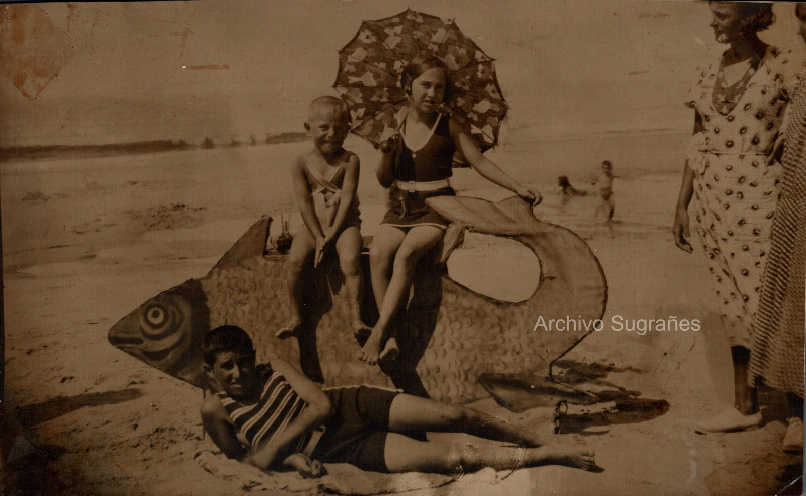 Niños en la playa sobre un gran pez