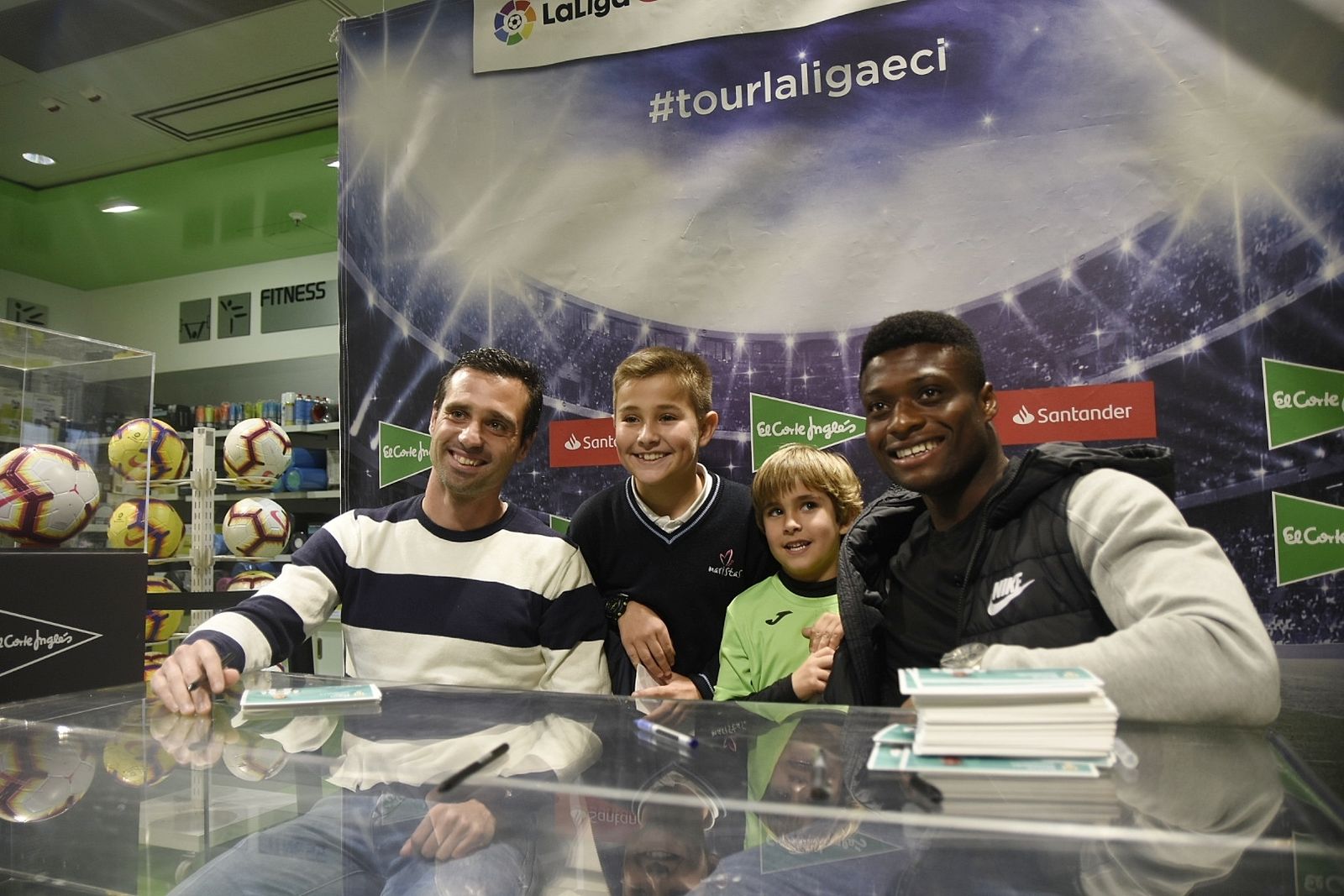 Miguel Flaño, junto a Neftali Manzambi y dos jóvenes seguidores en la firma de autógrafos.
