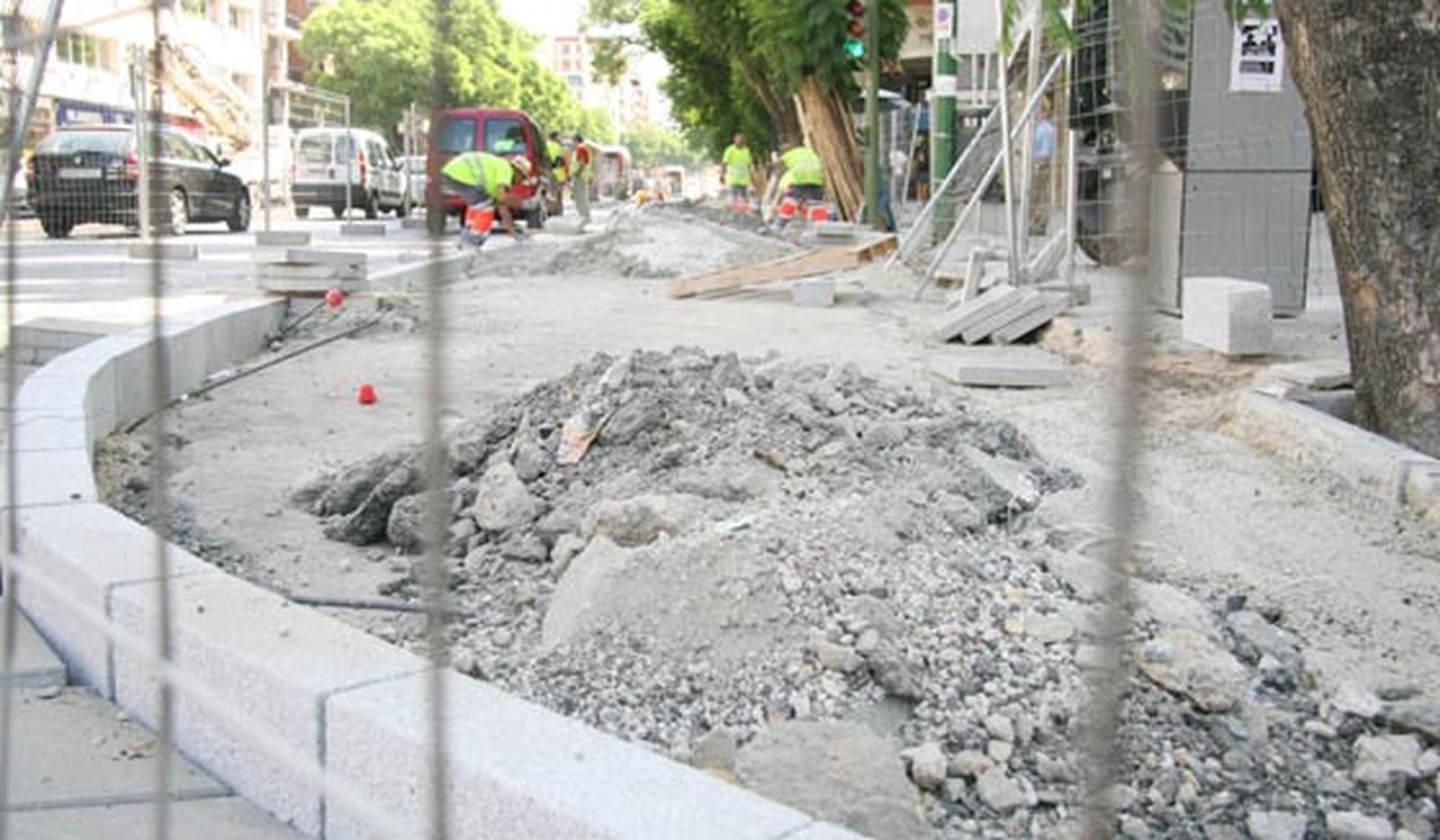 Coches circulan por la Avenida de Luis Montoto junto a los obreros que trabajan en la ampliación del carril bici./ Victoria Hidalgo
