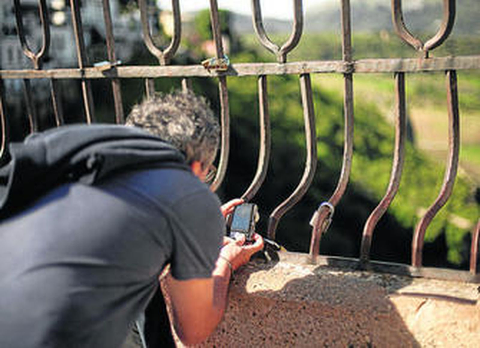 Un hombre fotografía varios de los candados.