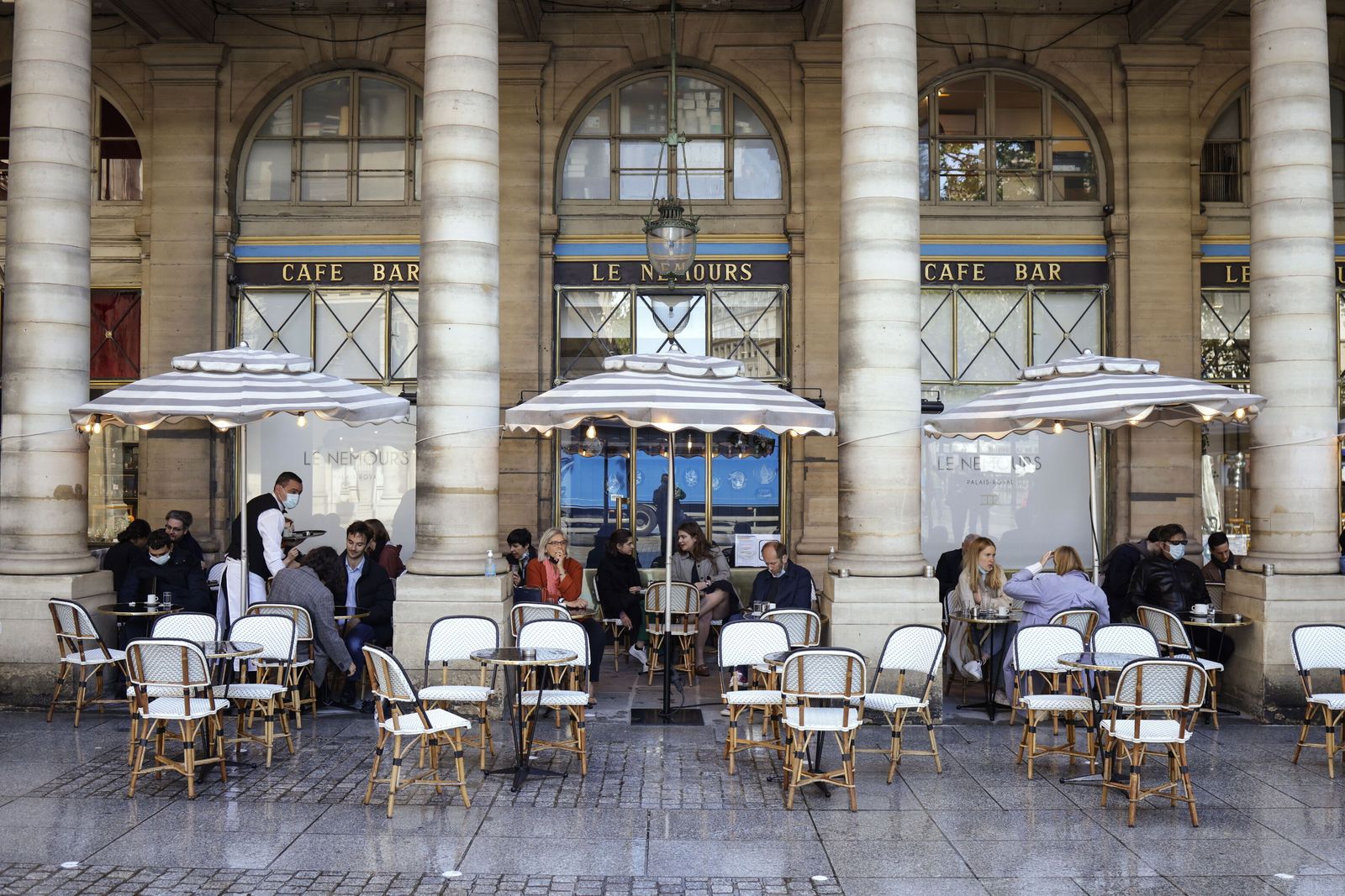 Parisinos tomando café en las inmediaciones del Louvre.