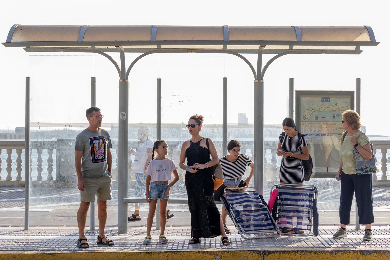 Varios usuarios esperando un autobús urbano en una parada de Cádiz