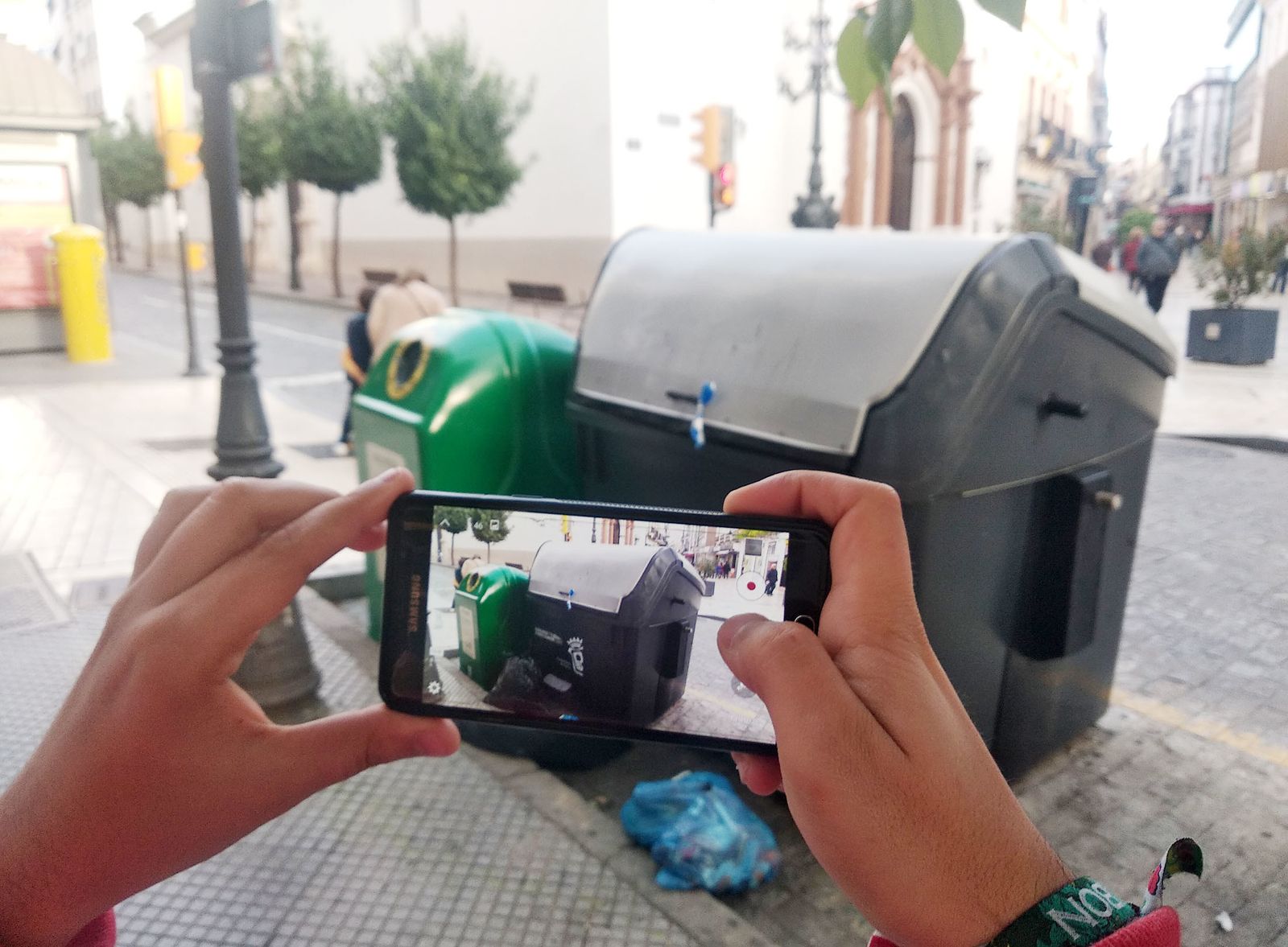 Un ciudadano saca una foto a un contenedor.