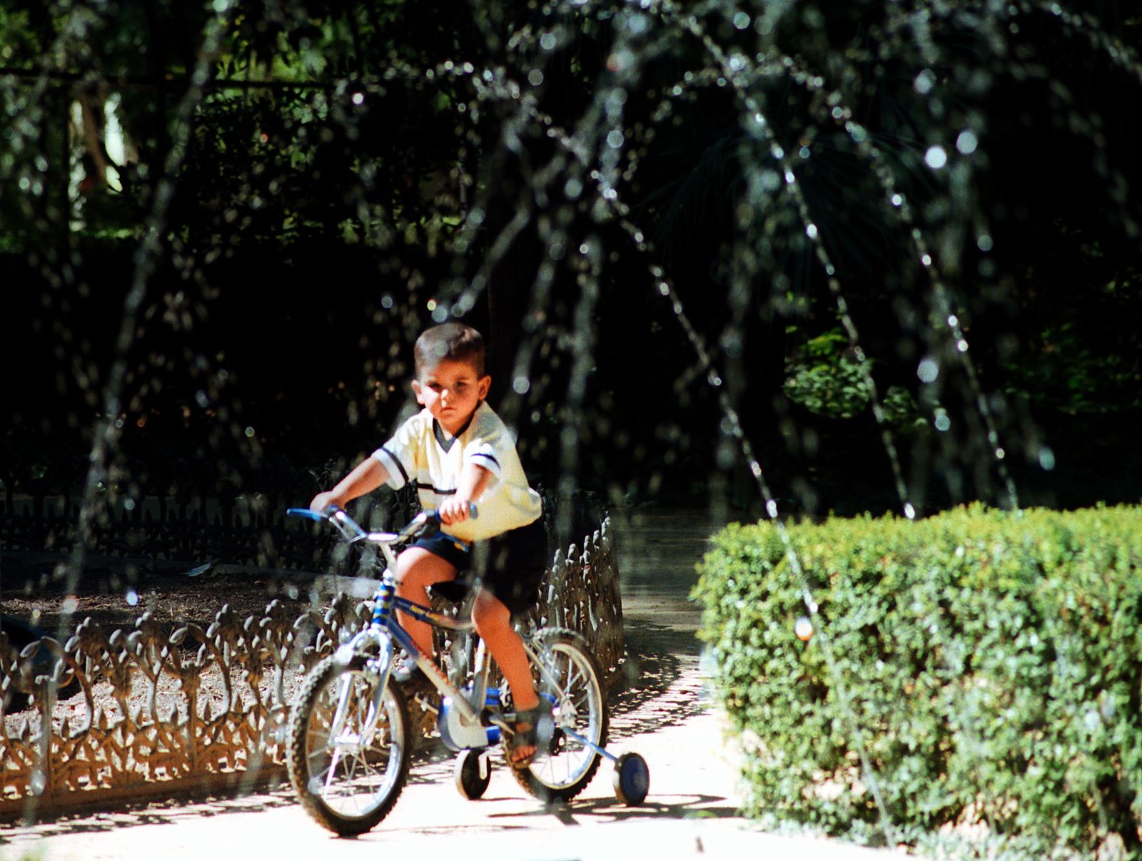 Un niño en bicicleta por el Parque de María Luisa.