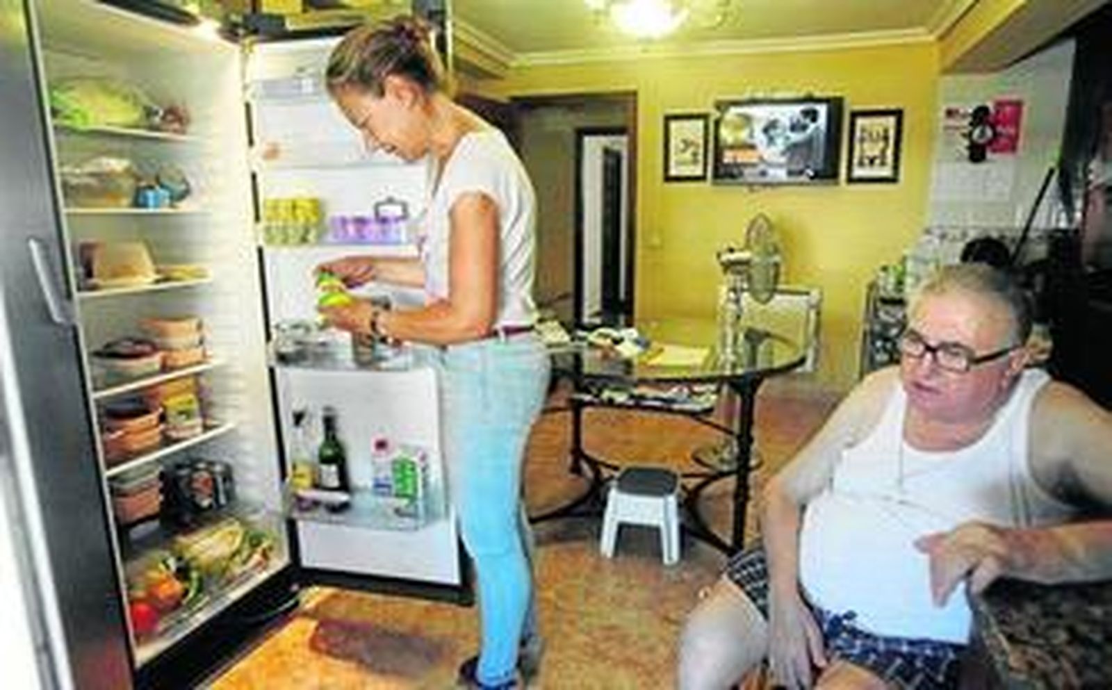 La enfermera que atiende a Pedro revisa el estado de los alimentos que tiene en el frigorífico.