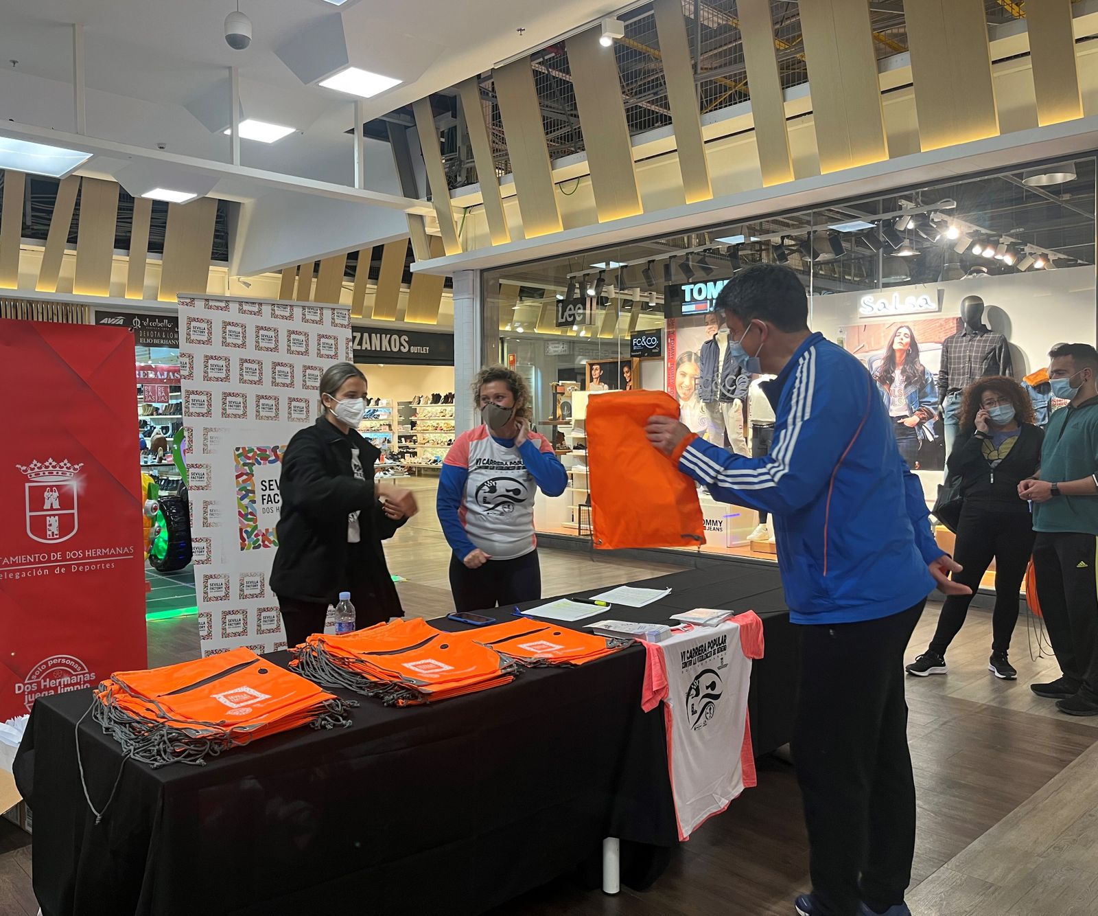 Entrega de dorsales de la VI Carrera Popular Contra la Violencia de Género en Sevilla Factory de Dos Hermanas.