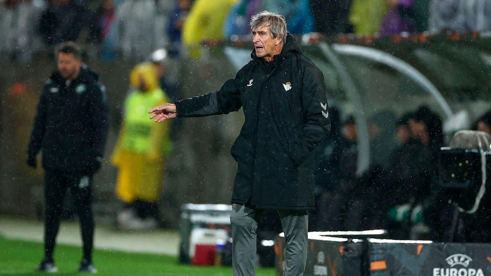 Manuel Pellegrini da instrucciones a sus jugadores bajo la lluvia.