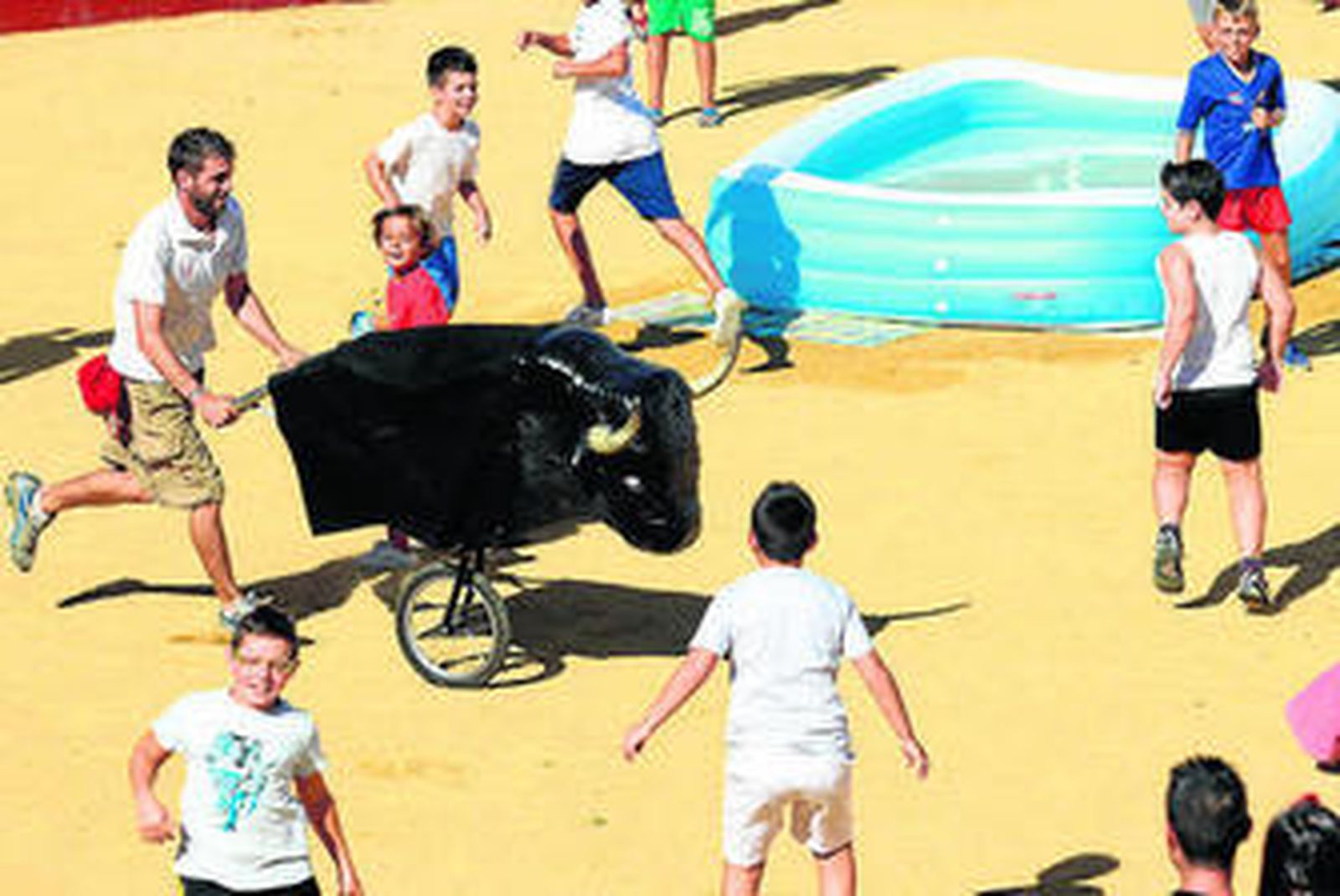 El toro infantil corre tras unos niños en el coso taurino de San Roque.
