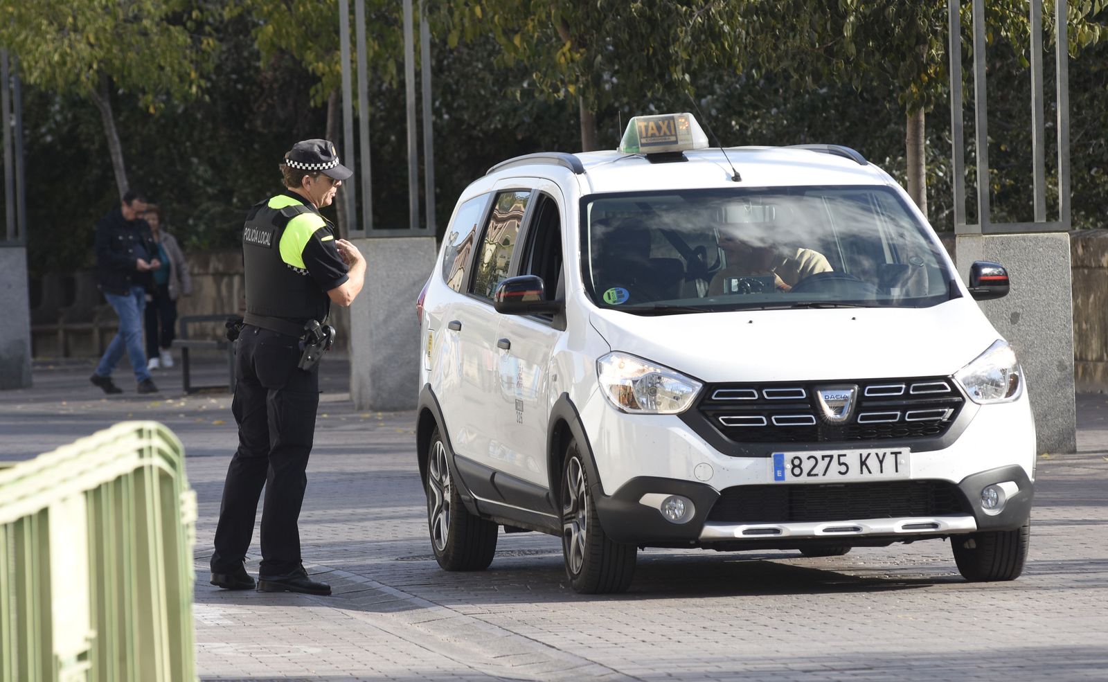 Un policía local conversa con un taxista.