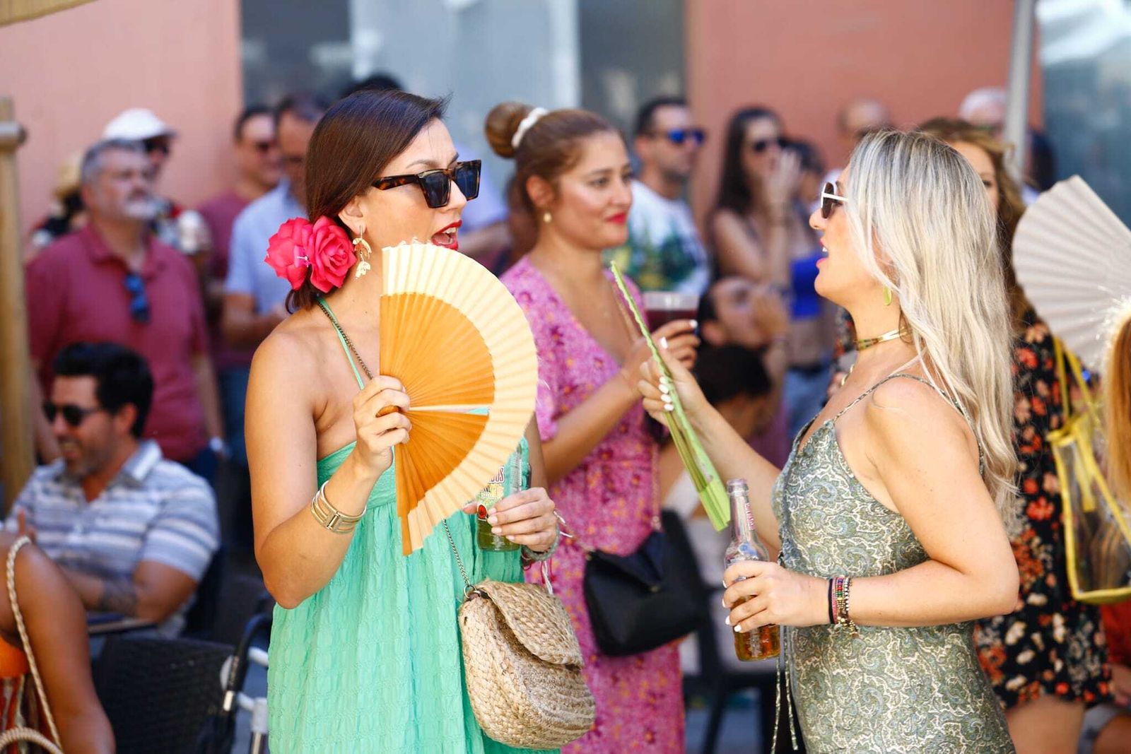 Un grupo de mujeres se abanica en la Feria de Málaga este sábado.