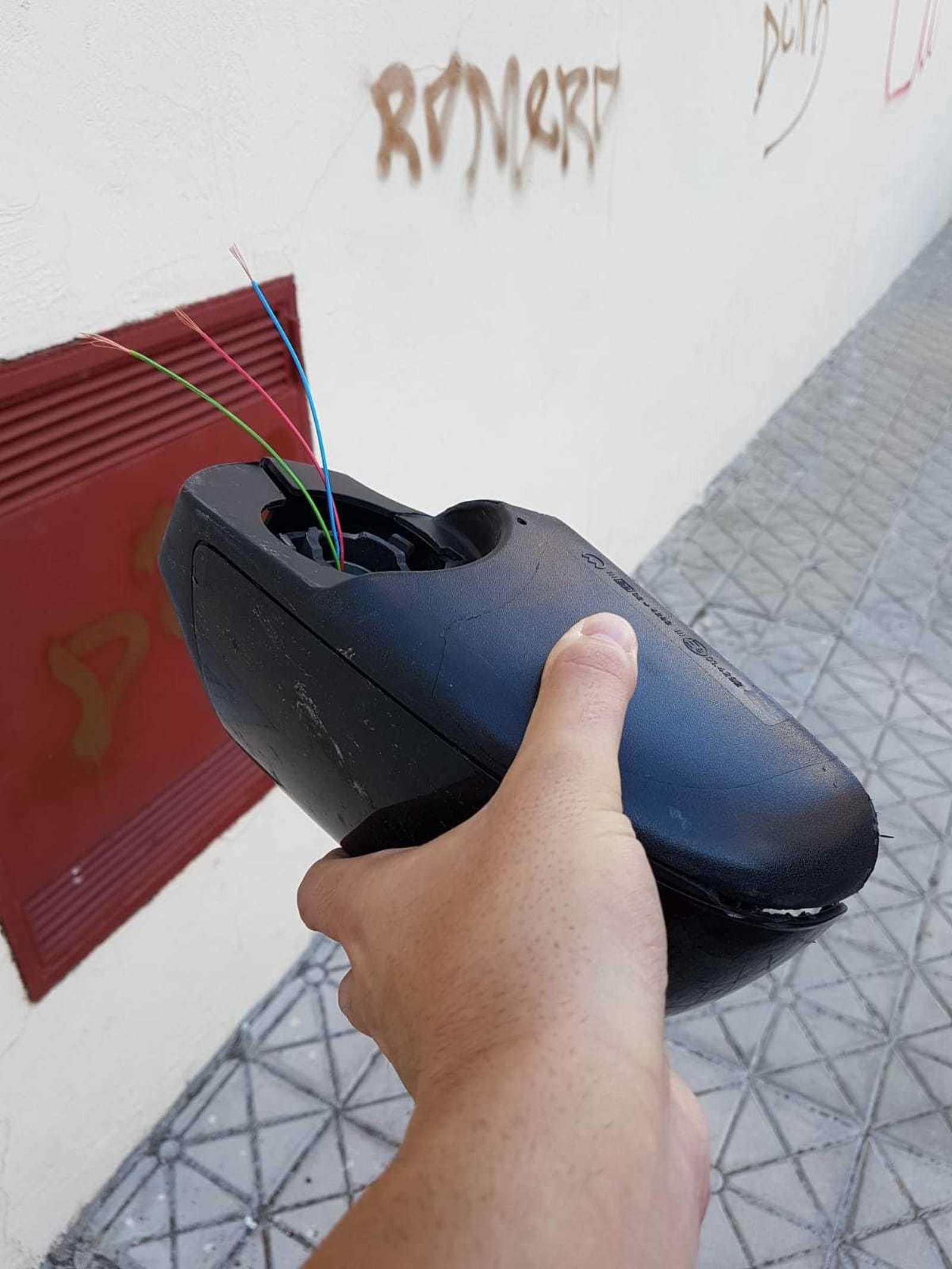 Espejo roto de uno de los vehículos aparcados.