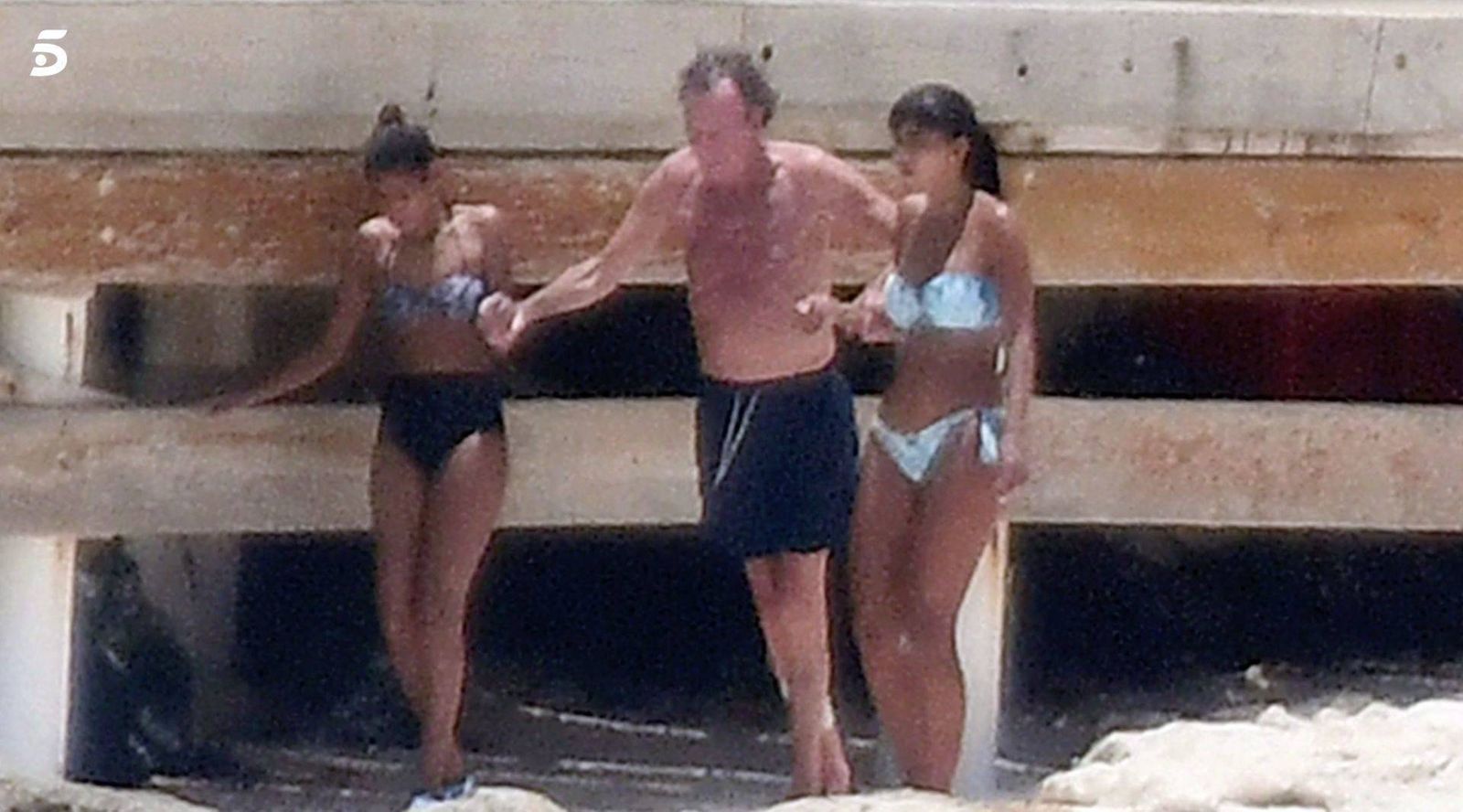 Julio Iglesias ayudado por dos chicas mulatas para poder bañarse cerca de su mansión en Punta Cana.