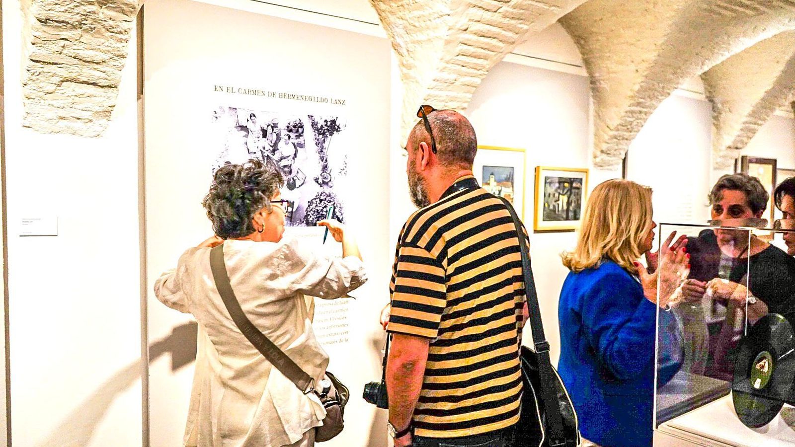 Varios visitantes charlan sobre la muestra.