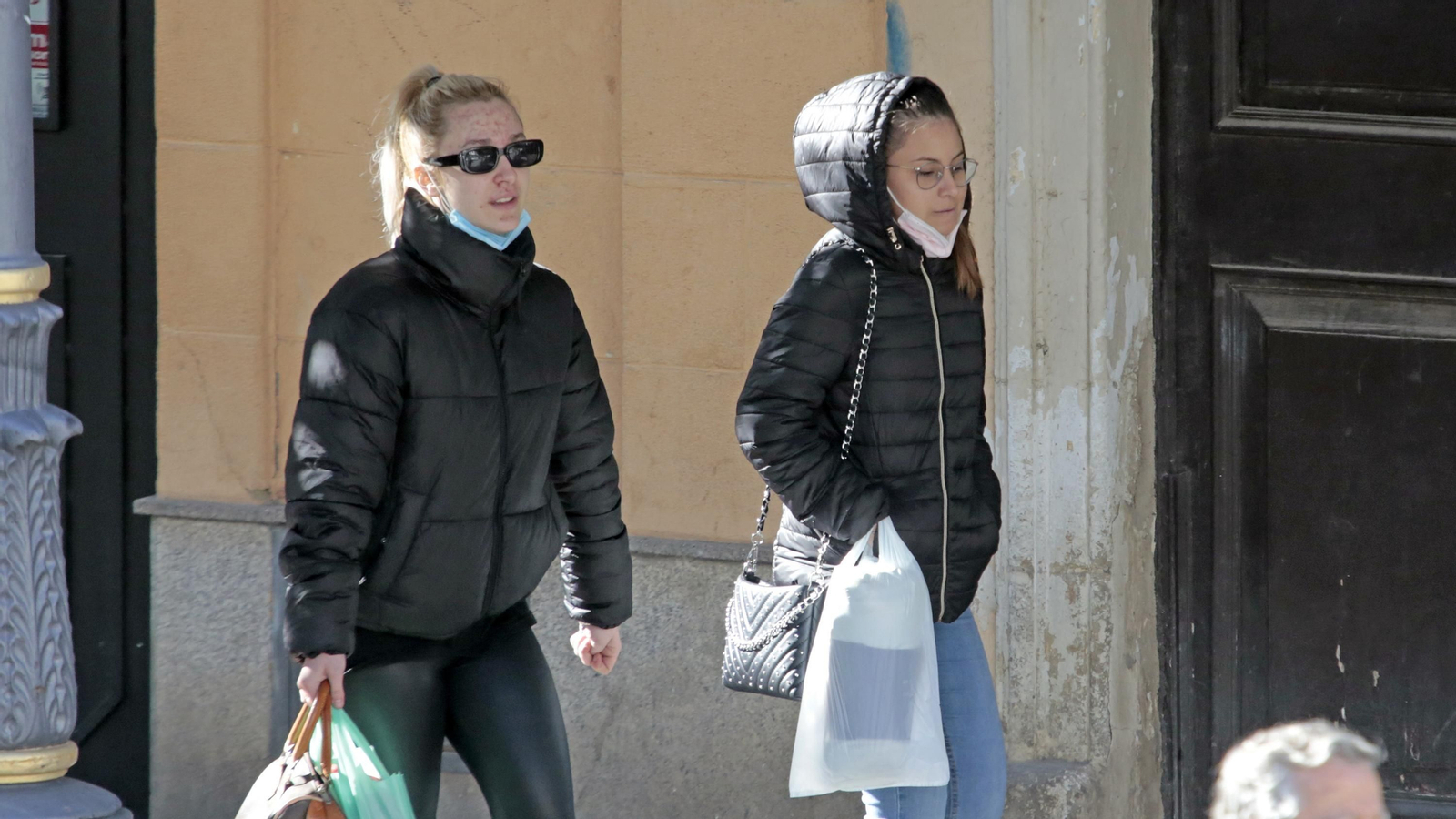 Dos mujeres pasean con la mascarilla bajada por una calle del centro.