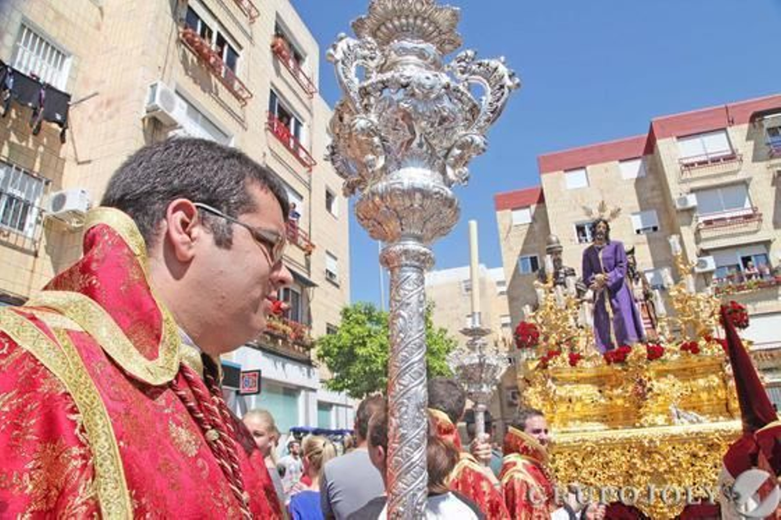 Un acólito precede la llegada del dorado paso de misterio de Nuestro Padre Jesús en su Soberano Poder rodeado de bloques de pisos en La Granja. Foto: Vanesa Lobo Un acólito precede la llegada del dorado paso de misterio de Nuestro Padre Jesús en su Soberano Poder rodeado de bloques de pisos en La Granja. Foto: Vanesa Lobo