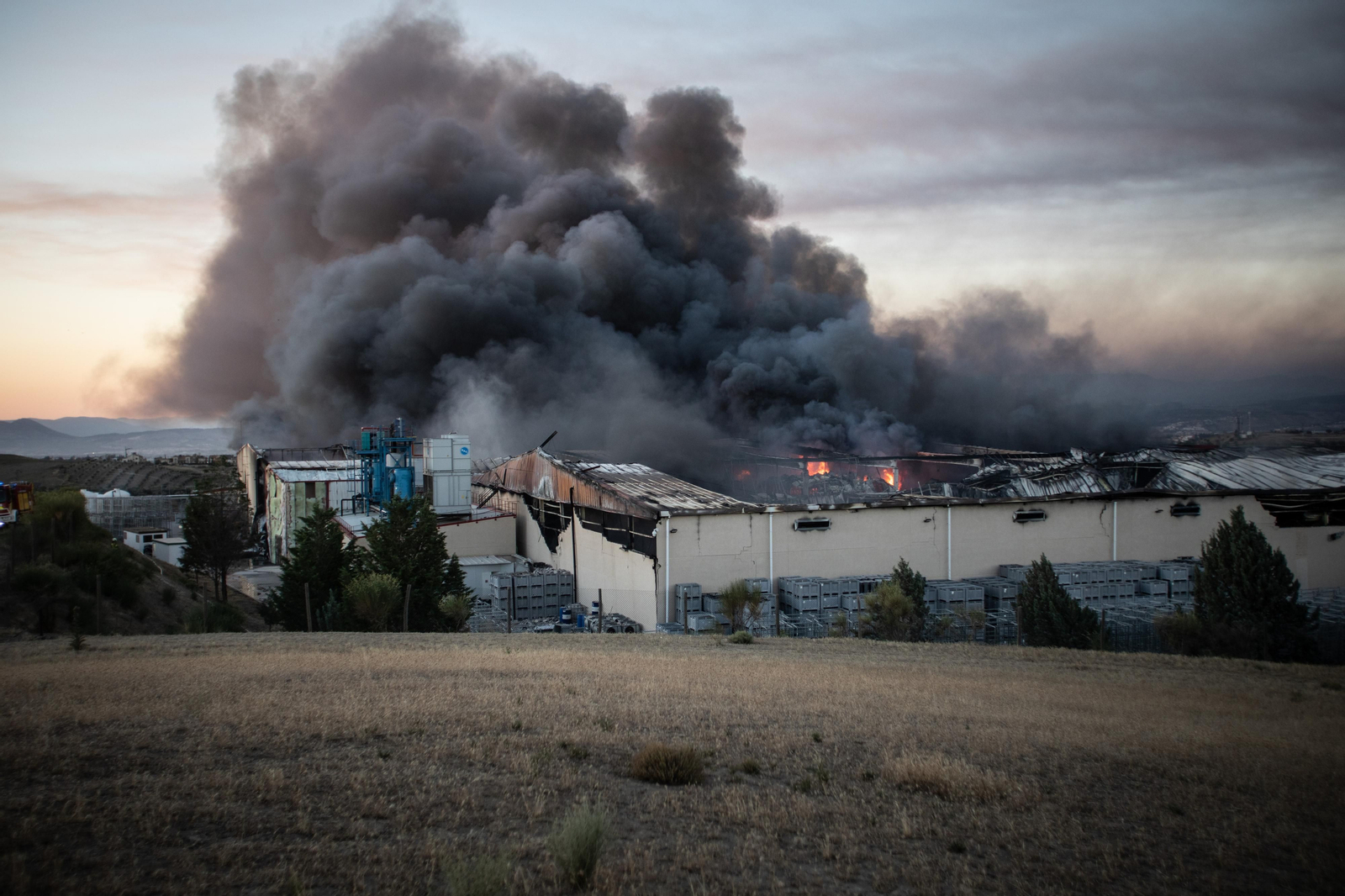 Las imágenes del incendio en una nave de Otura y la columna de humo que cubre Granada