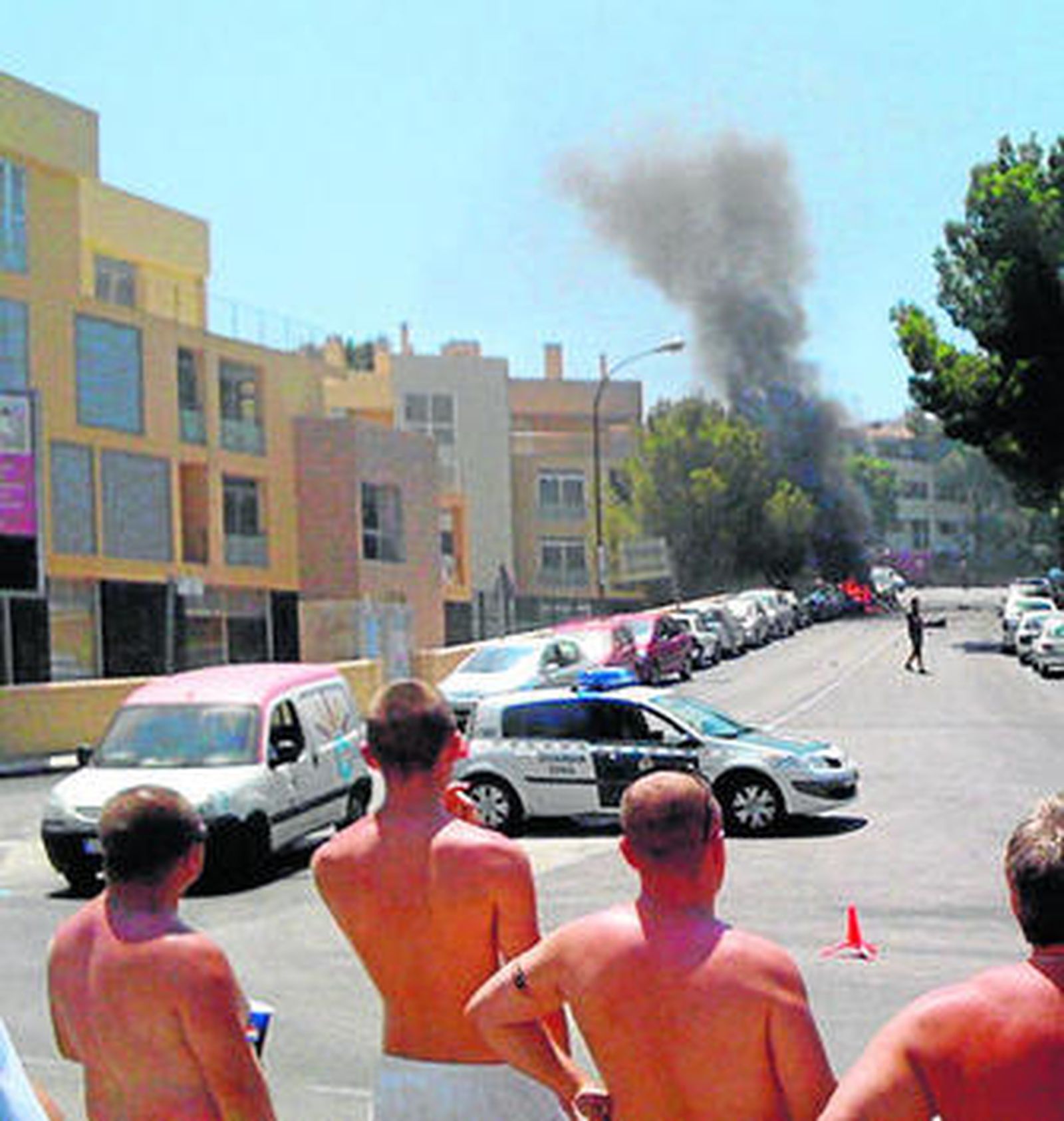 Bañistas ante la humareda del coche-bomba que mató a dos guardias civiles en 2009.