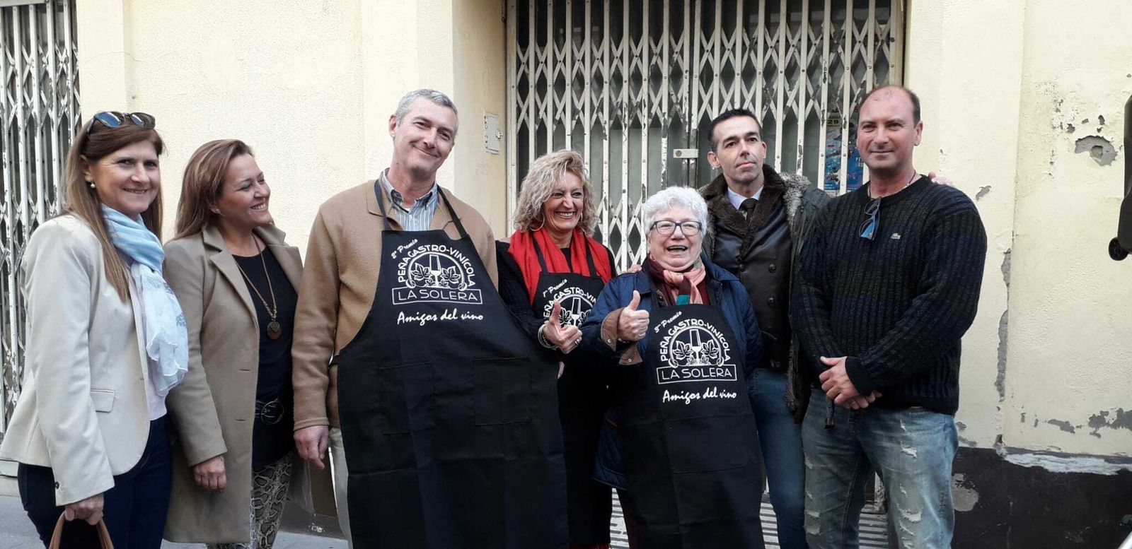 Los tres ganadores, en el centro,  posan con sus delantales de la peña.