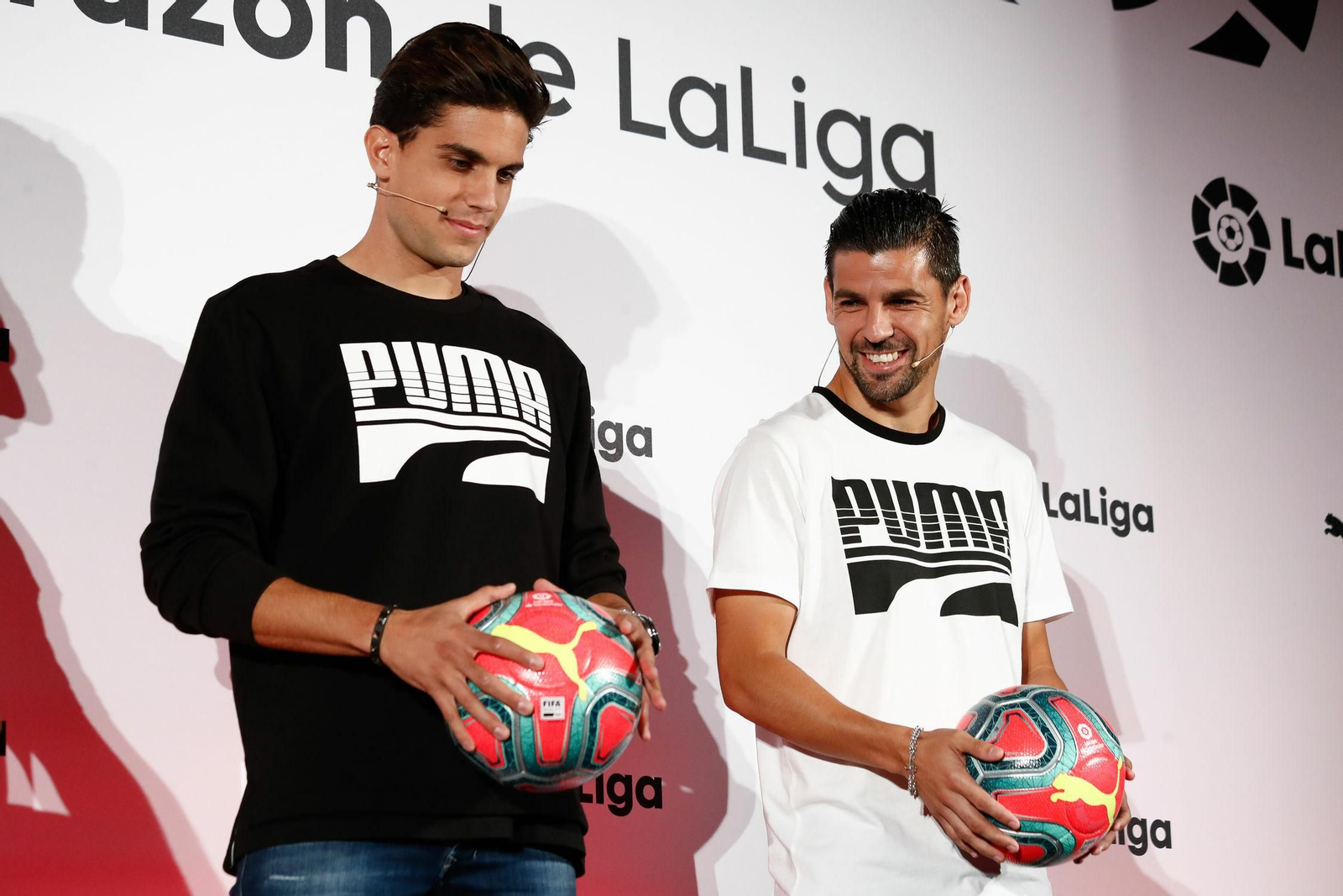 Nolito sonríe junto a Bartra en la presentación del balón de invierno, de color rosa.