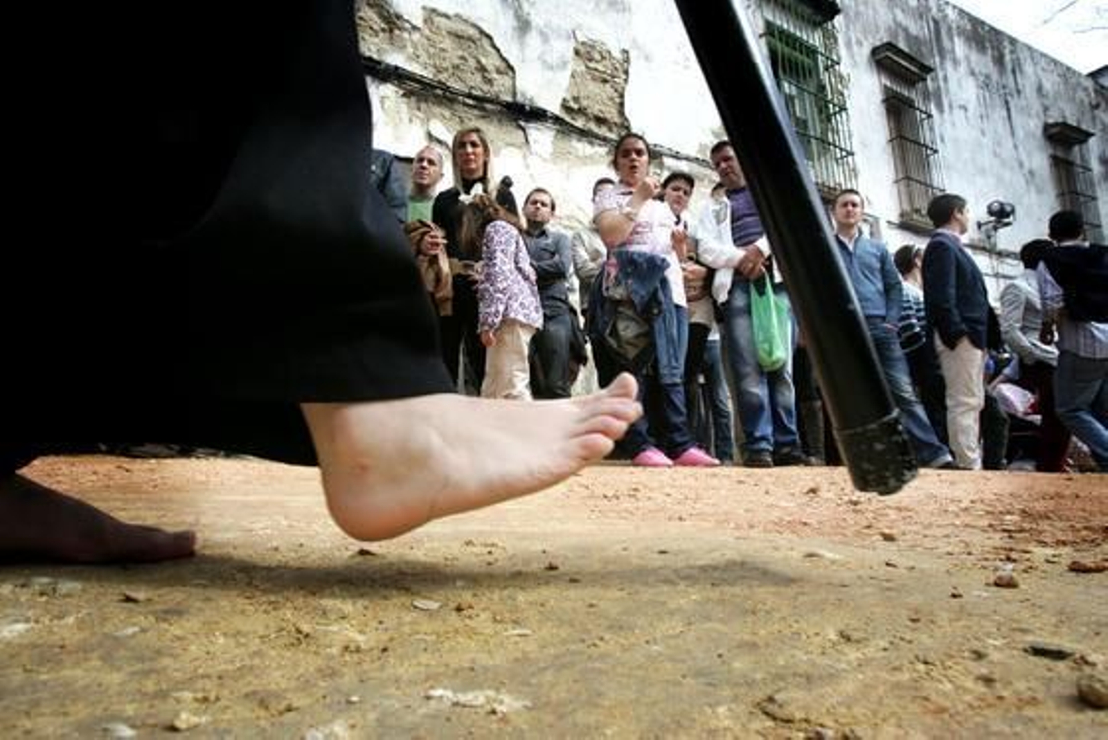 Desnudos. Los pies descalzos de un nazareno de Las Tres Caídas por el casco antiguo.

Foto: Pascual