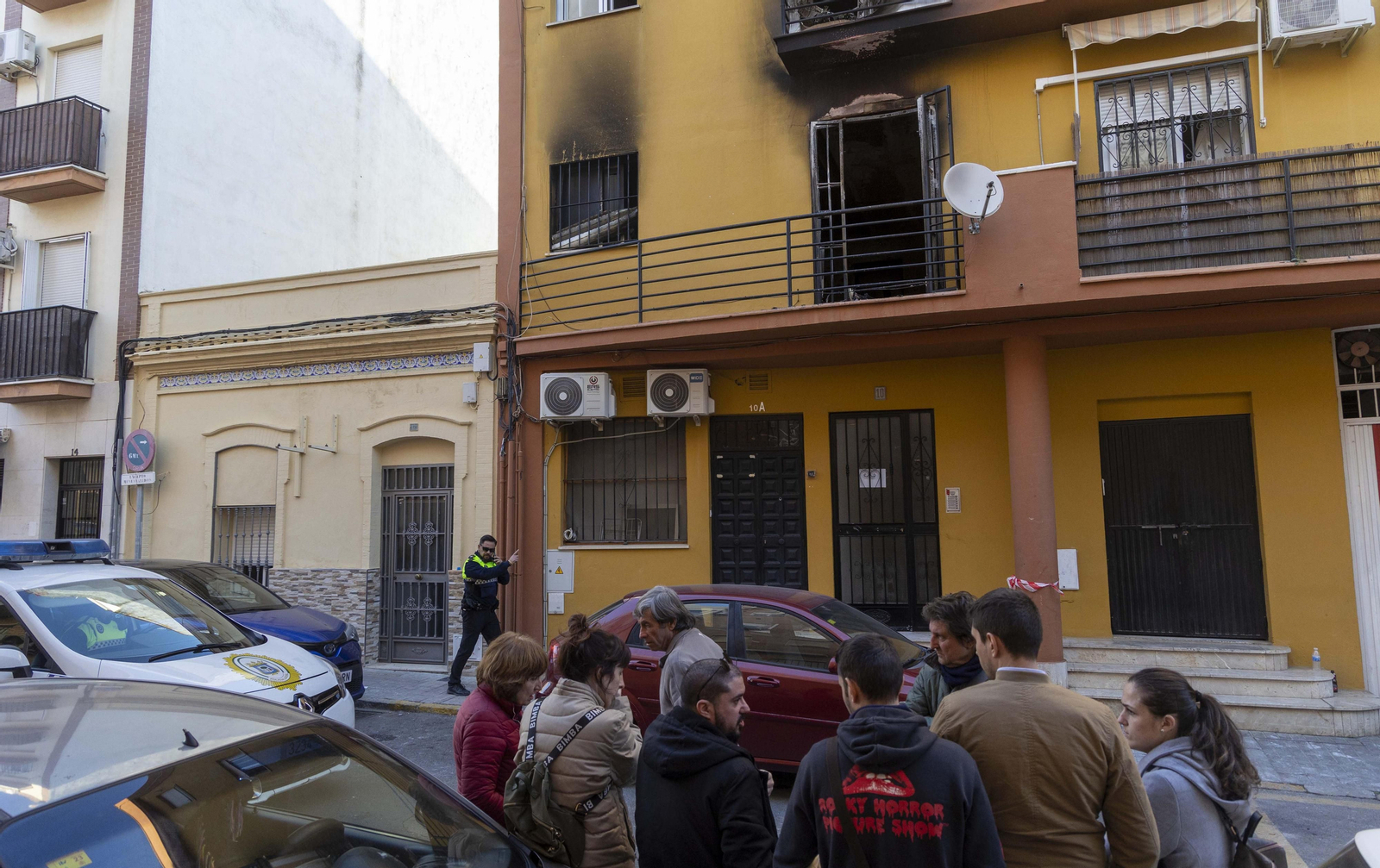 Vecinos y familiares de éstos, en la puerta del bloque incendiado.