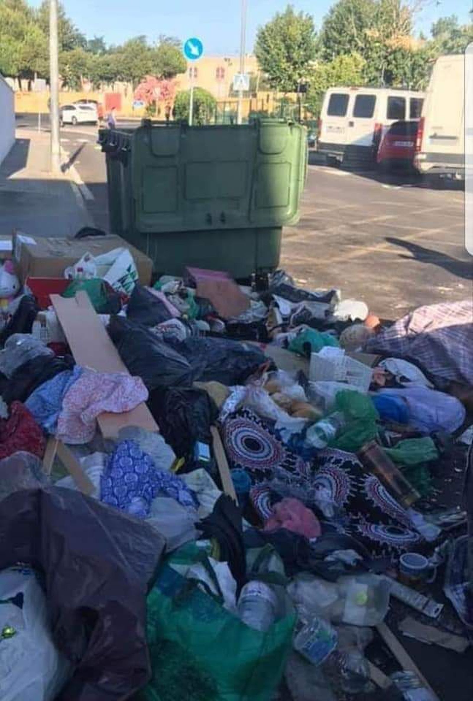 Restos de ropa junto a contenedores en Camas.