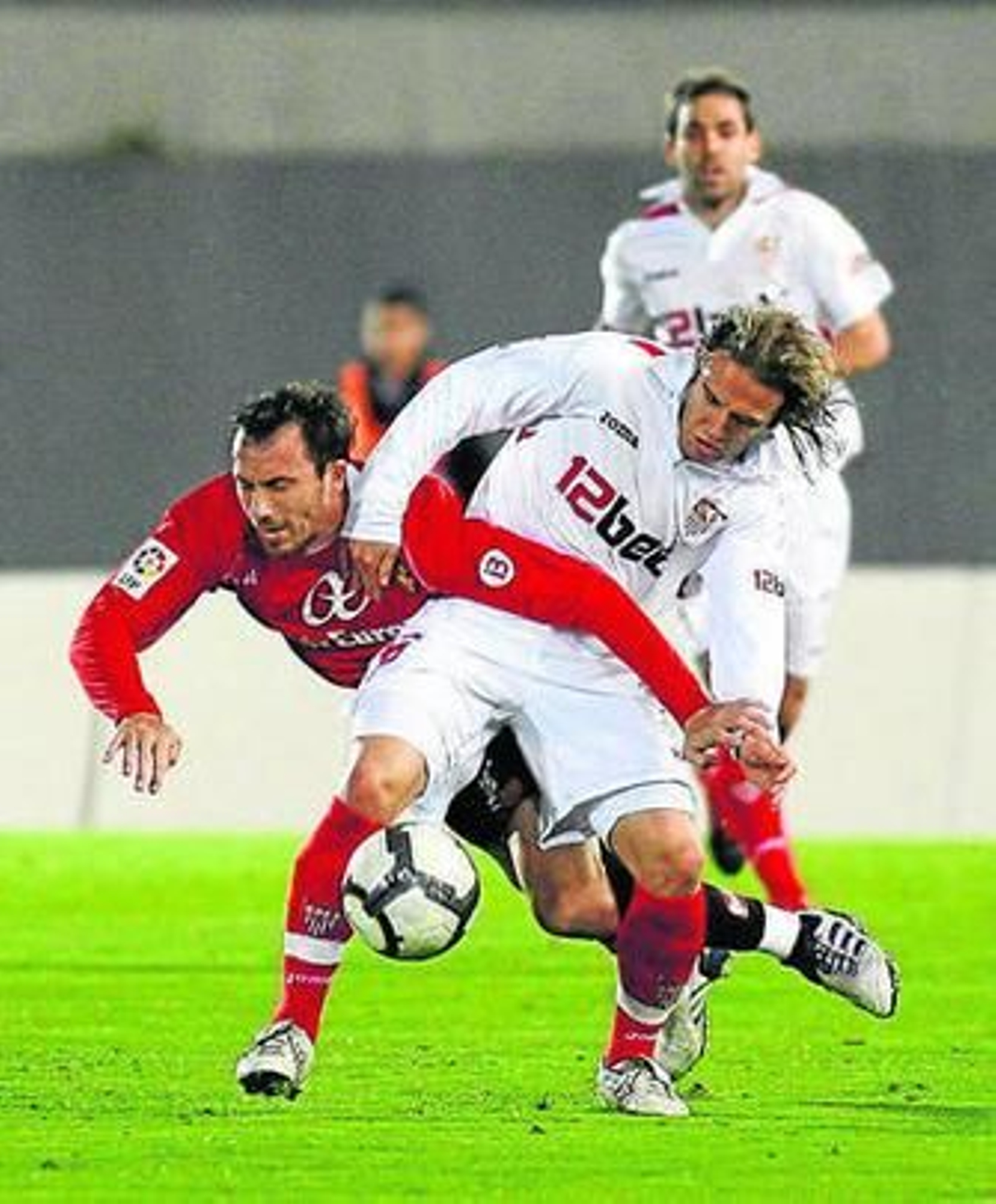 Josemi cae ante Diego Capel en la disputa de un balón.
