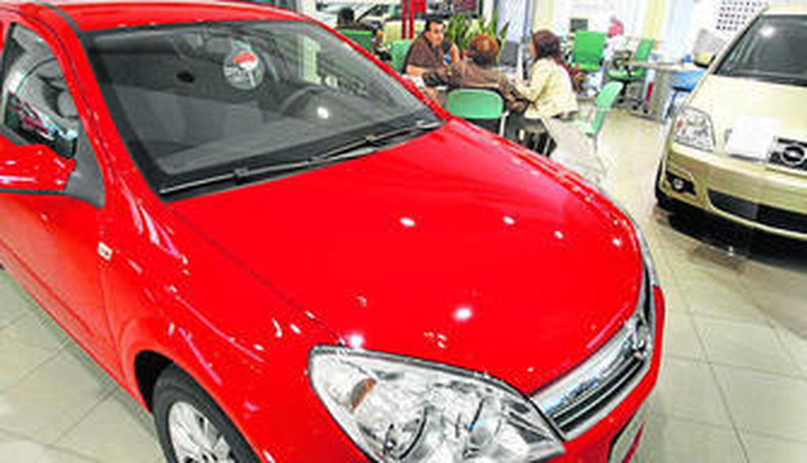 Varios clientes en un concesionario de coches.