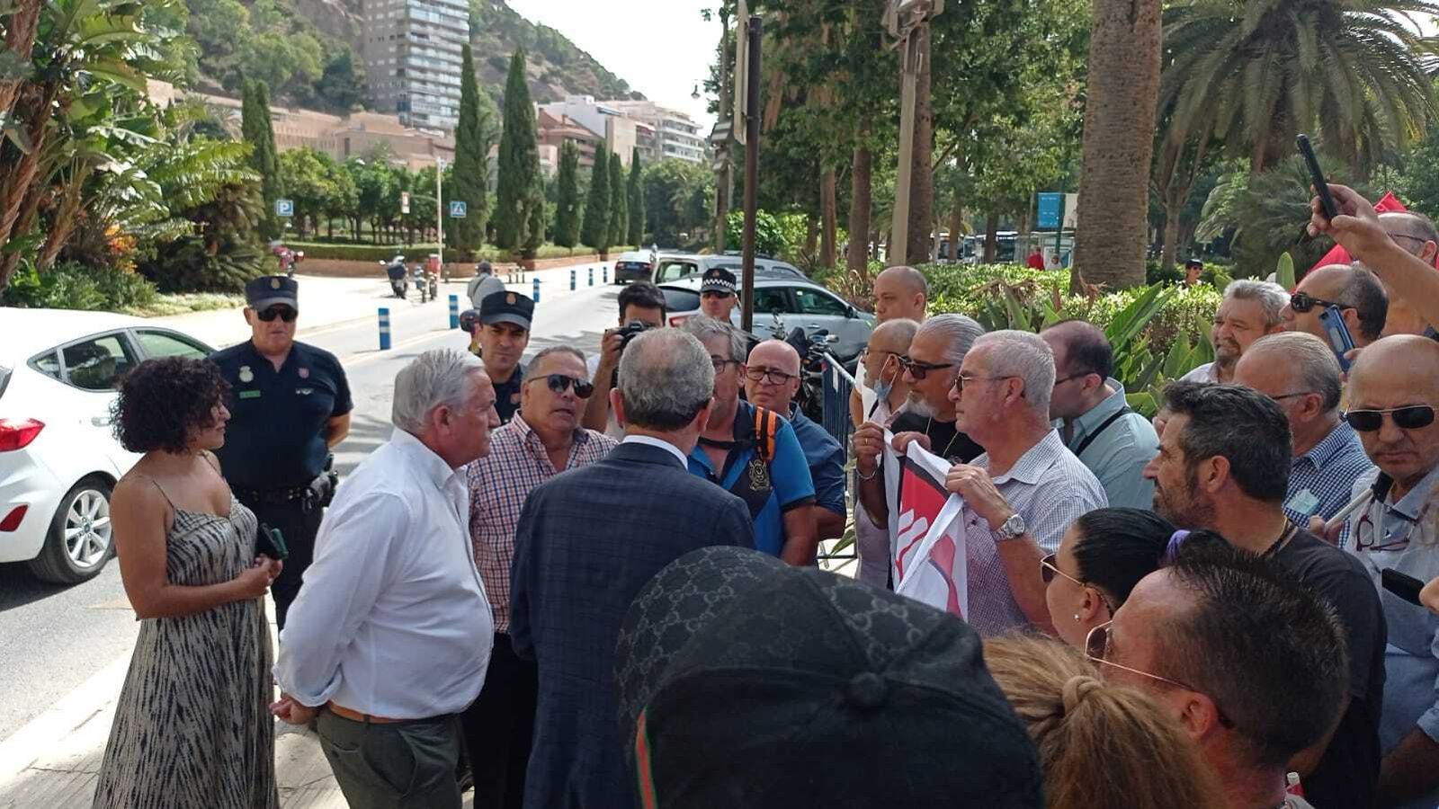 El alcalde (de espaldas) junto al concejal de Movilidad, reunido con los taxistas asalariados a las puertas del Ayuntamiento.