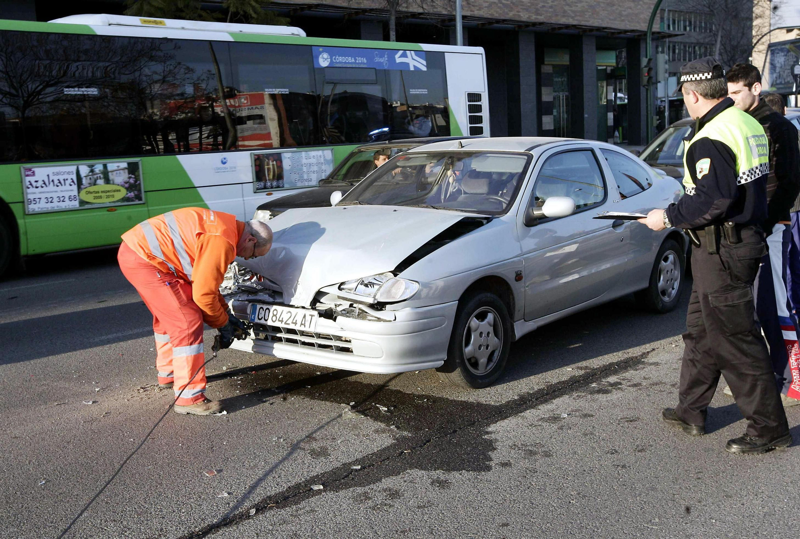 Operario de la grúa municipal se dispone a retirar un vehículo siniestrado.