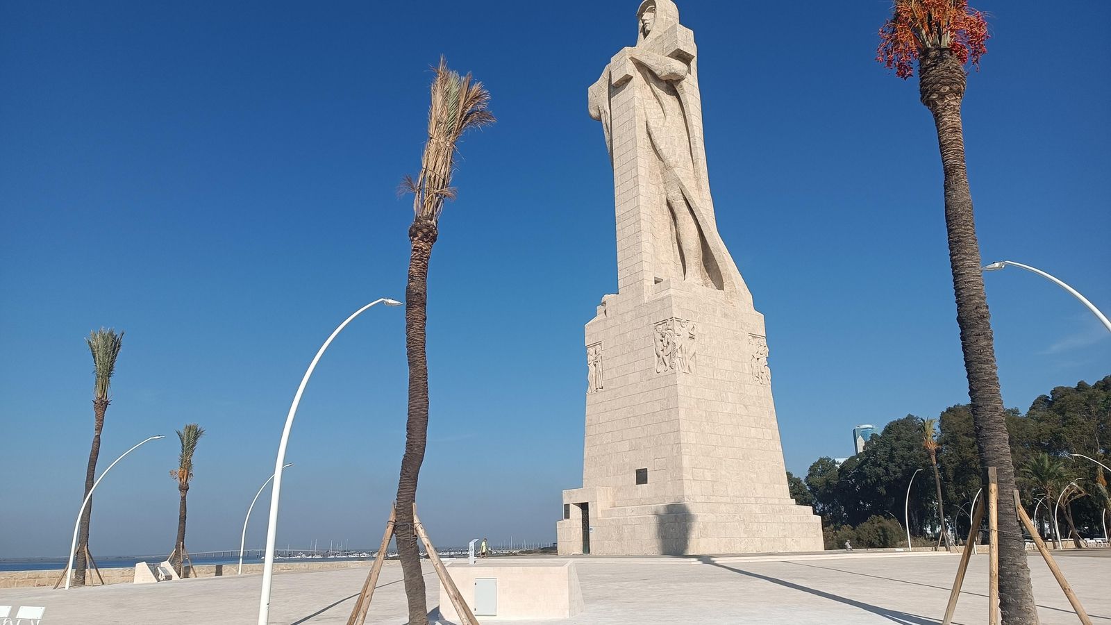 El  Monumento a Colón recupera su espacio egipcio con más palmeras y pavimento que recuerda la tierra del desierto.