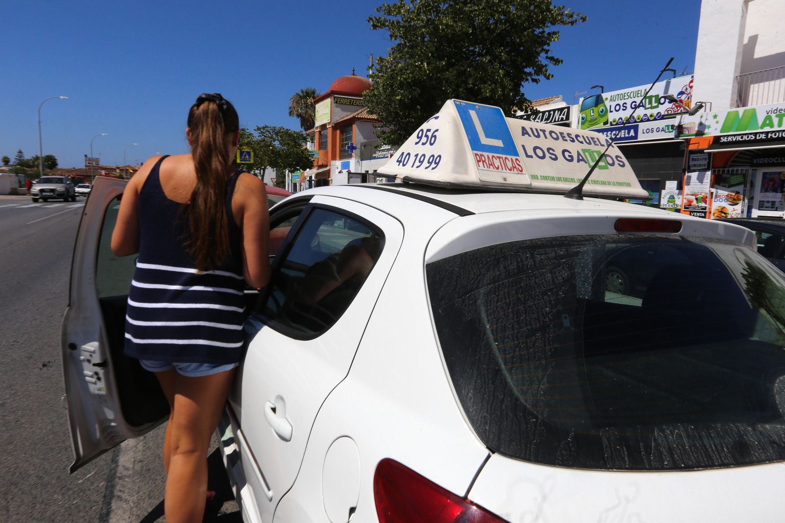 Una joven se dispone a dar clases en un vehículo de prácticas de una autoescuela situada en la urbanización Los Gallos.