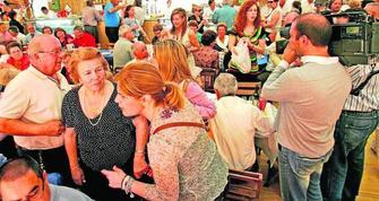 Pelayo saluda a unos mayores durante el almuerzo de ayer, mientras al fondo la alcaldesa hace lo propio.