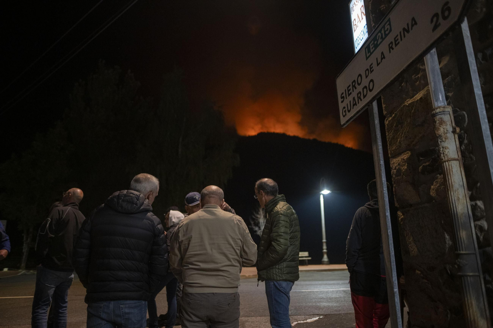 Varias personas observan el incendio en Boca de Huérgano, León, la pasada noche.