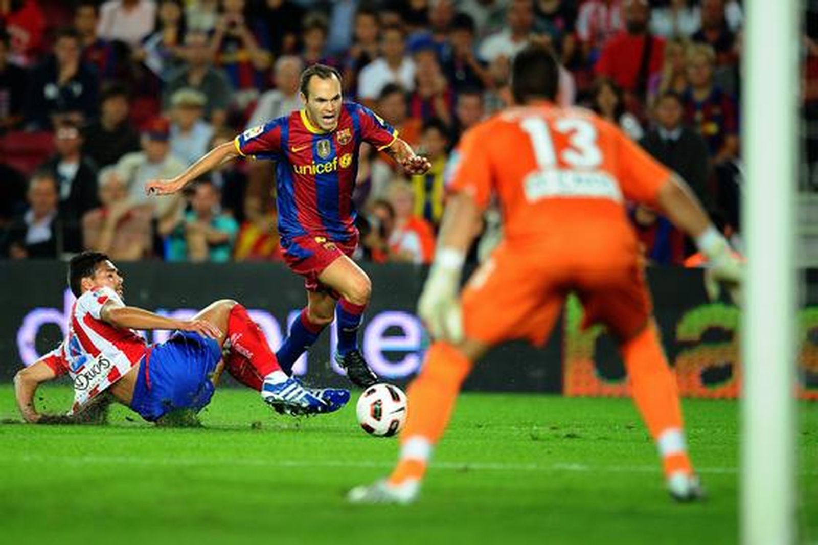 Iniesta encara al portero del Sporting tras evitar a un defensa. / AFP