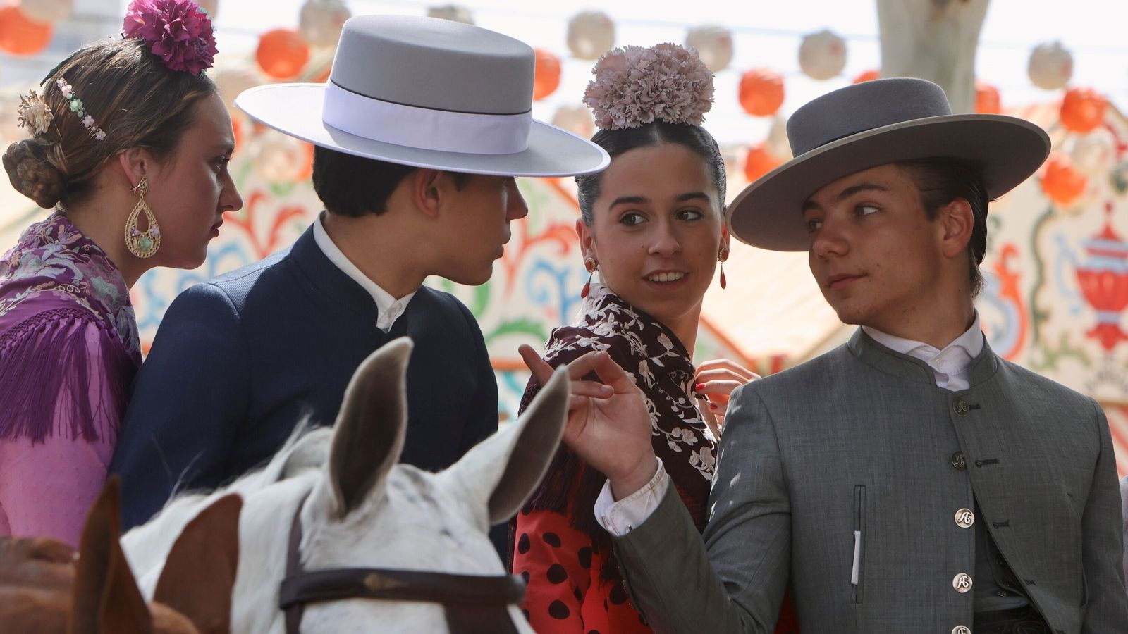 Dos caballistas y dos flamencas charlan animadamente.