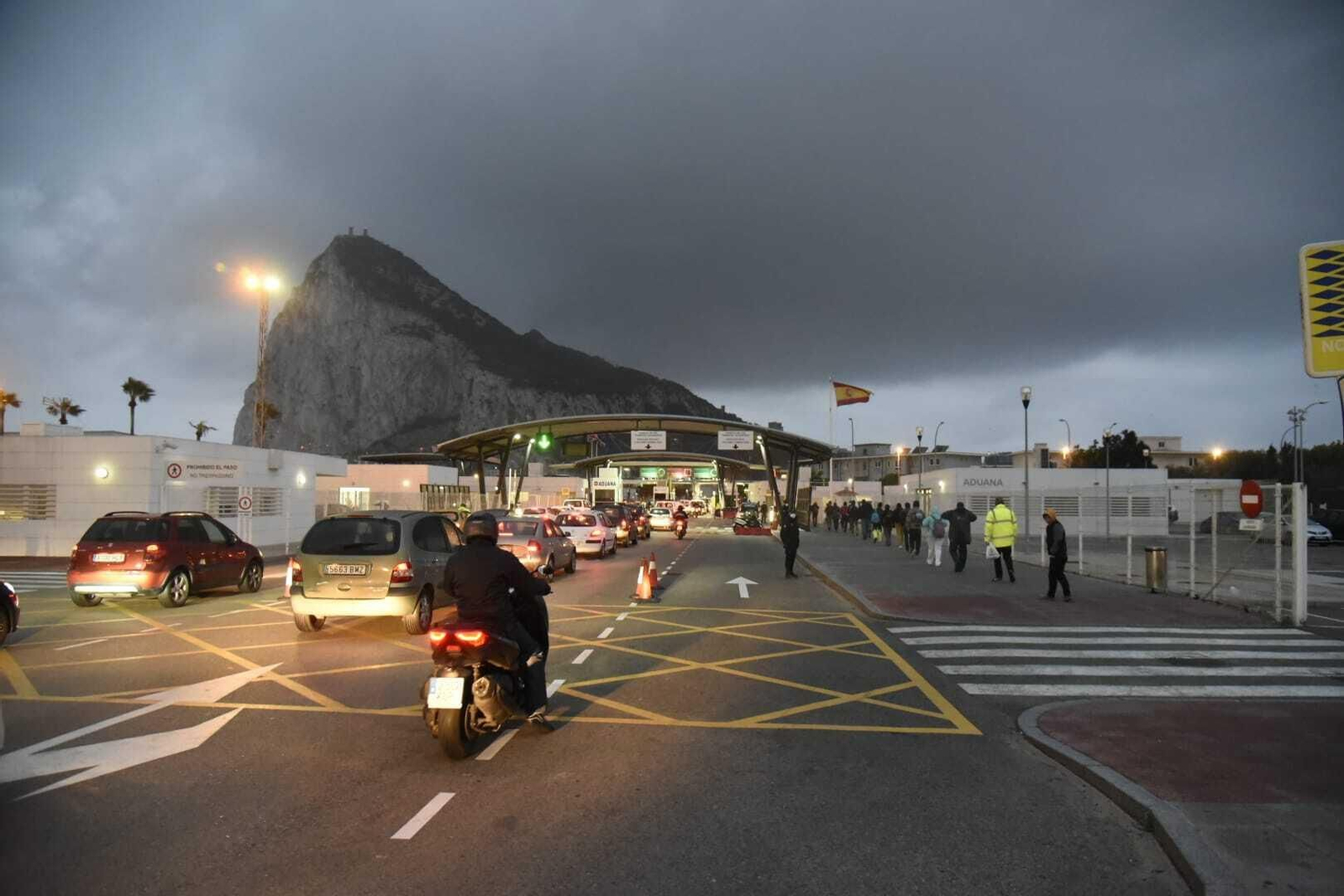 Colas de vehículos y peatones, en la mañana de este viernes.