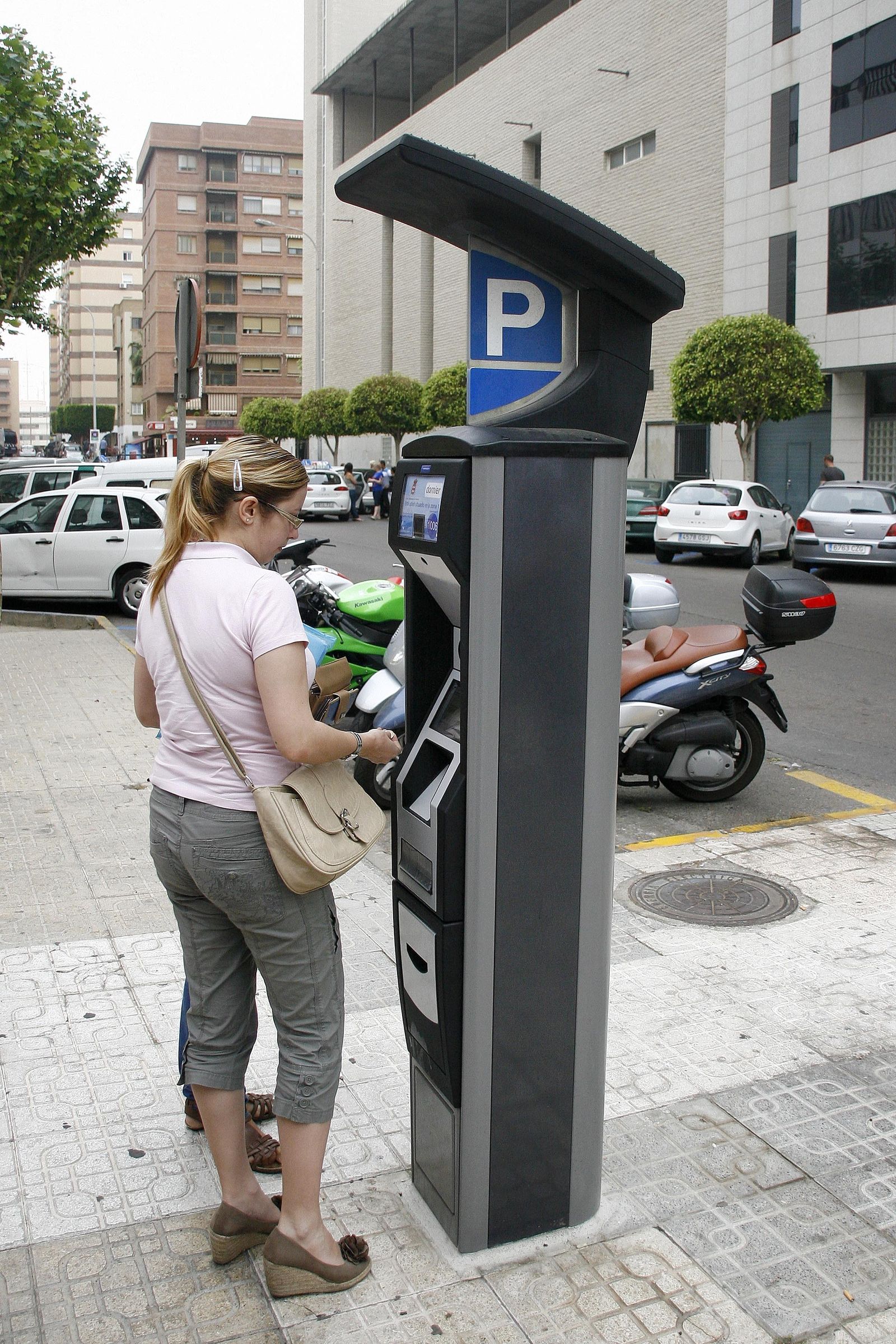 Una usuaria saca el tique de la zona azul en Oliveros.