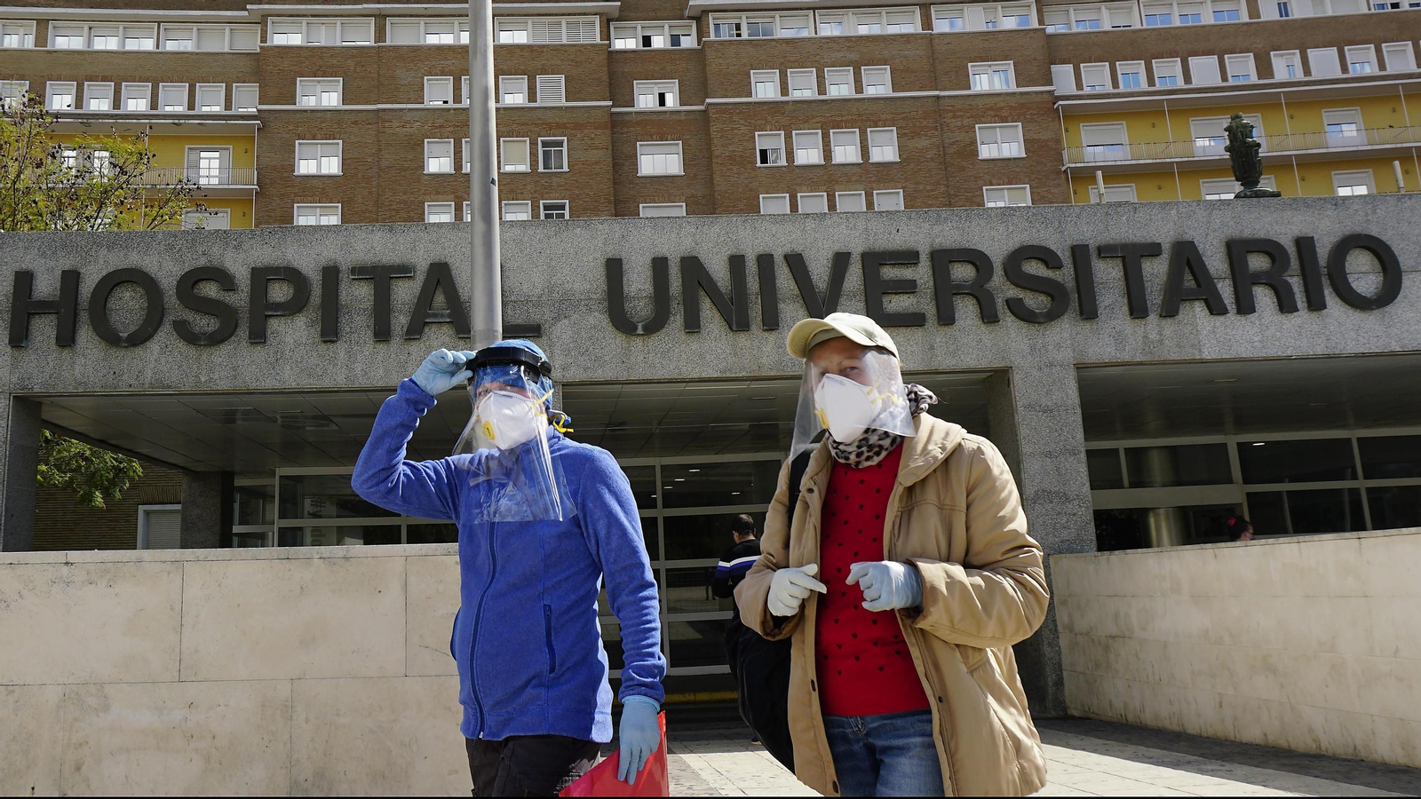 Dos personas con protección facial, junto al Virgen del Rocío.