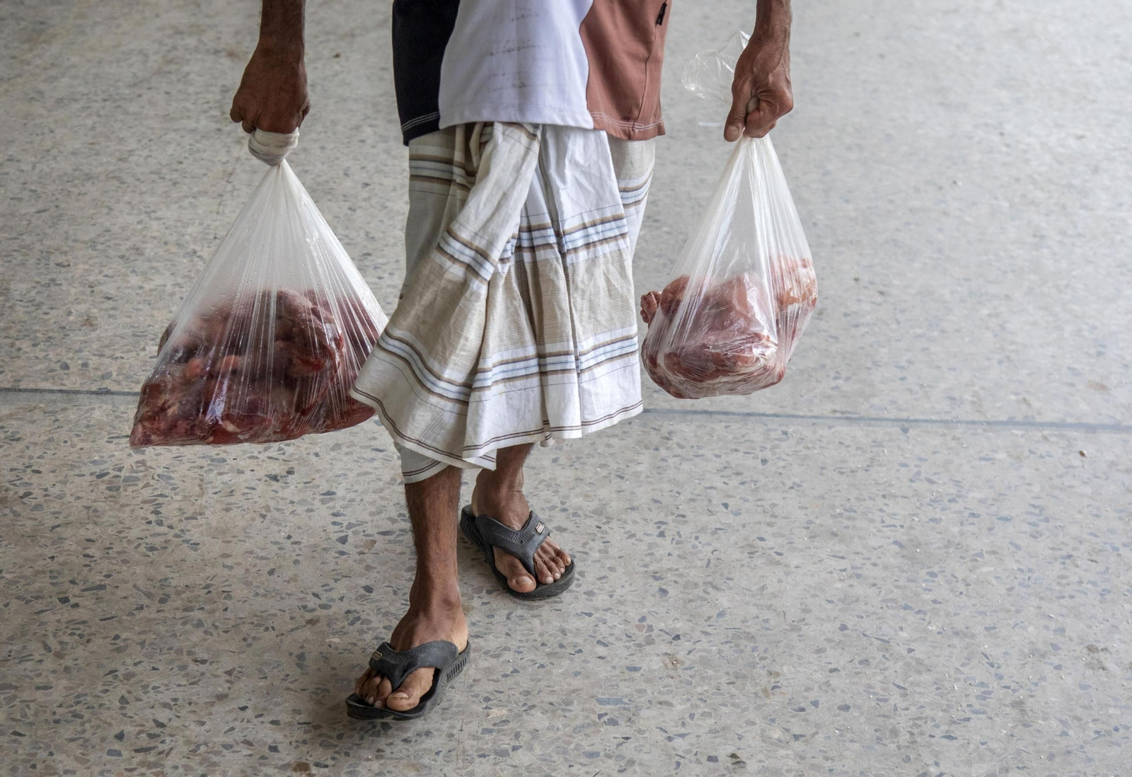 Un hombre carga dos bolsas con carne tras las celebraciones del Eid-al-Adha. Un hombre carga dos bolsas con carne tras las celebraciones del Eid-al-Adha.