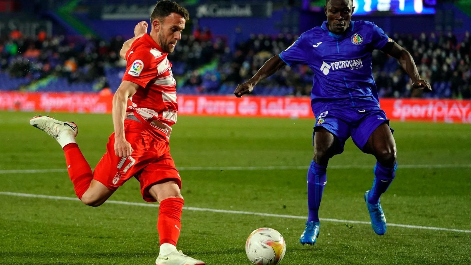 Quini centra ante Djene en un ataque del Granada