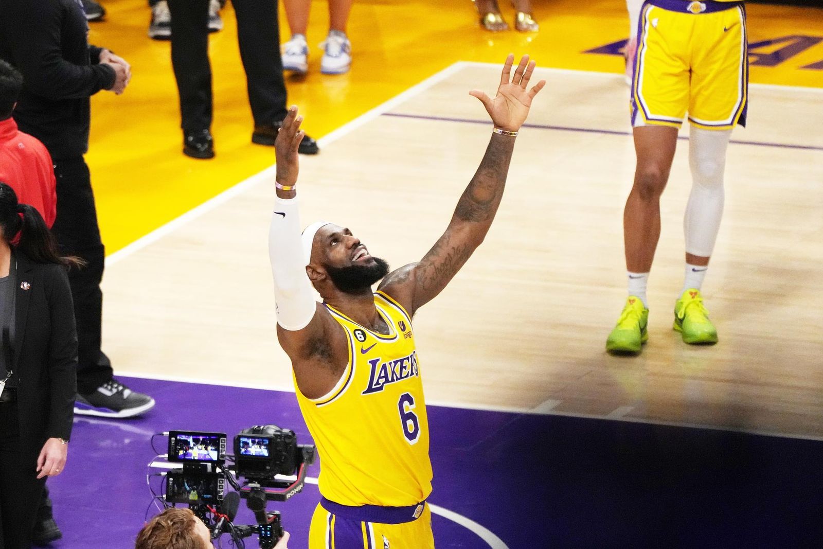 LeBron James alza los brazos tras superar la marca histórica de puntos.