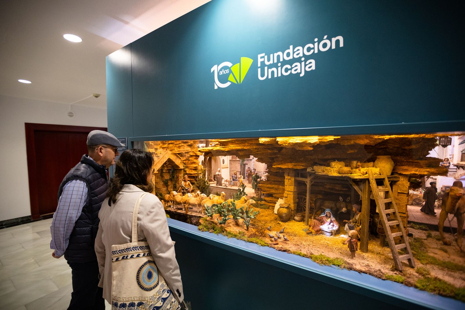 Dos personas contemplan el belén artístico instalado en el Centro Cultural Fundación Unicaja en Almería.