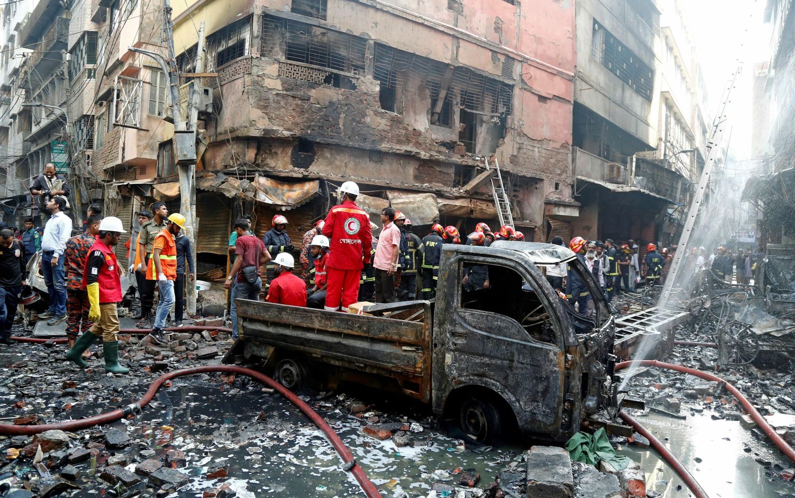Los bomberos inspeccionan los escombros tras el incendio en Dacca (Bangladesh).