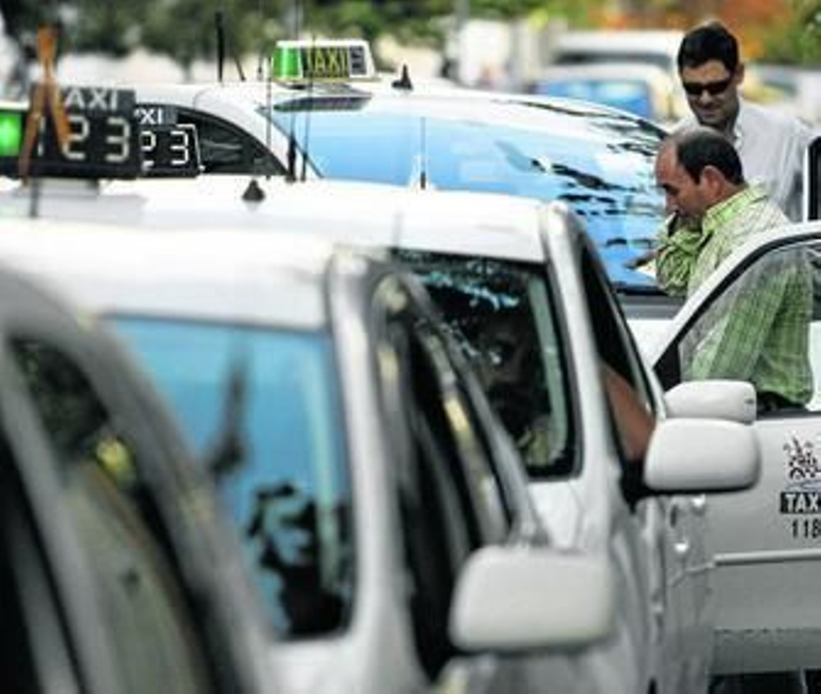 Una hilera de taxis aguarda en una parada de un barrio de la ciudad.