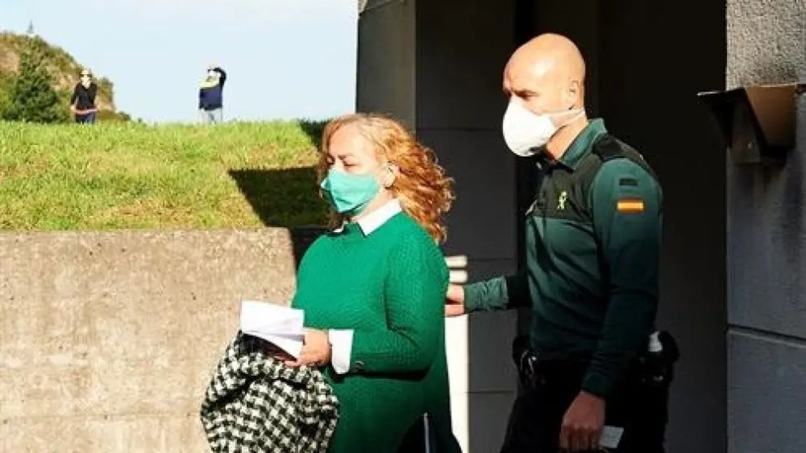 Mamen Merino es conducida a los juzgados por un agente de la Guardia Civil.