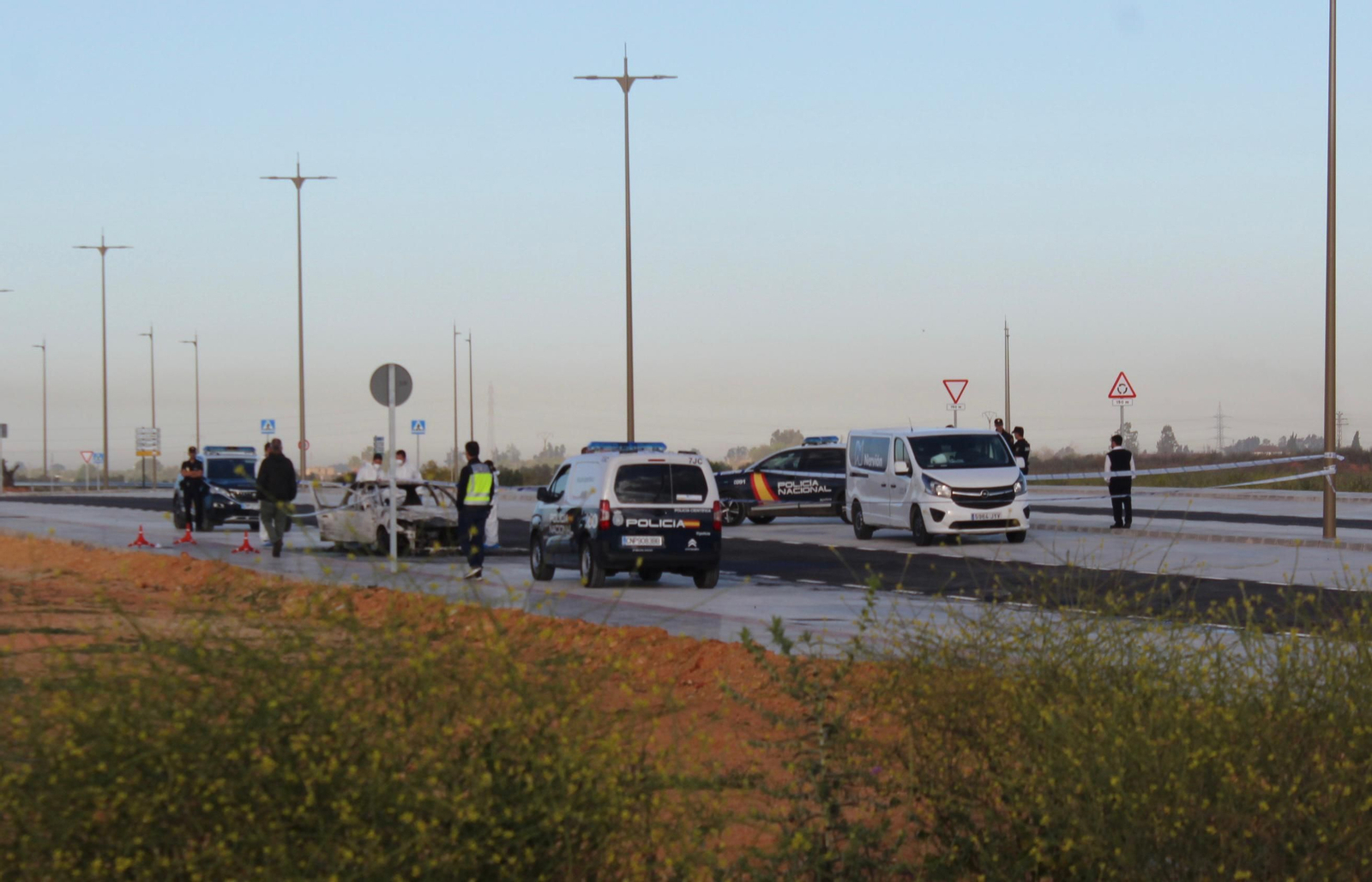 El vehículo donde ha aparecido el cadáver junto a los investigadores de la Policía Nacional.