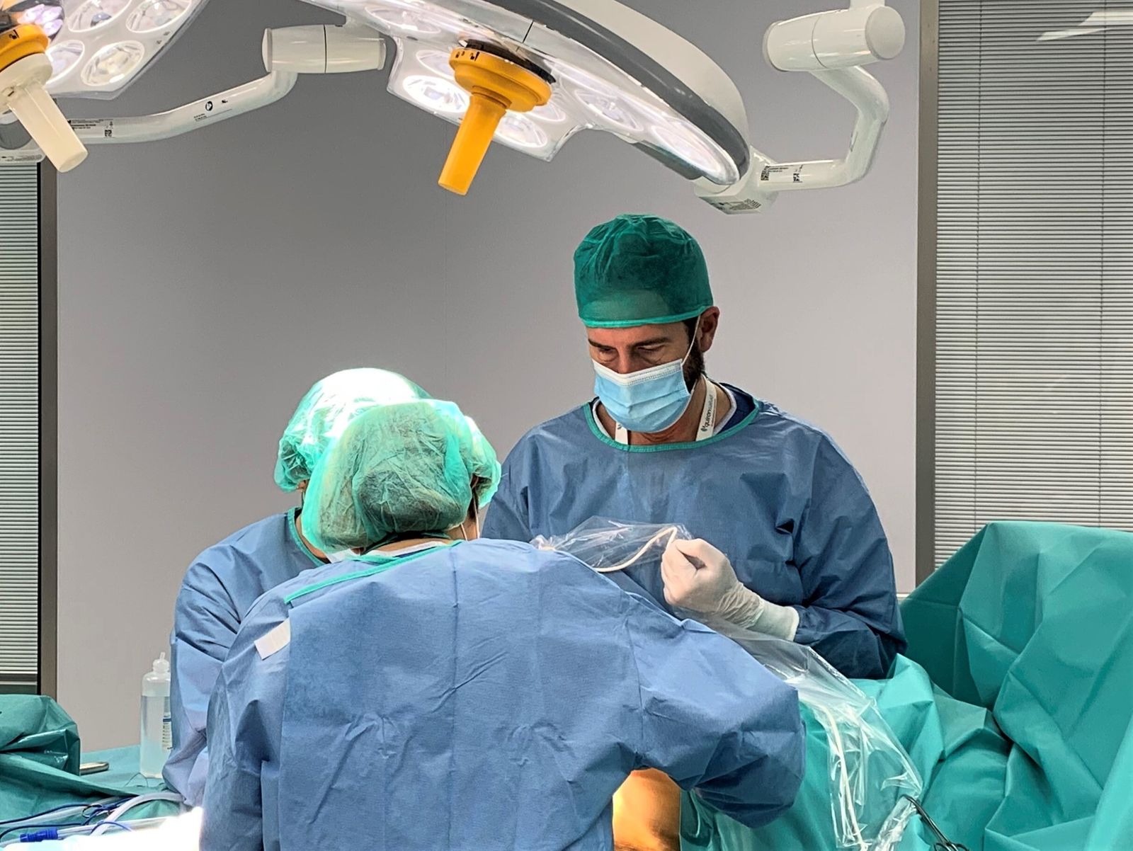 Los doctores Espiñeira (de espaldas) y Contreras realizan una biopsia de ganglio centinela en quirófano.